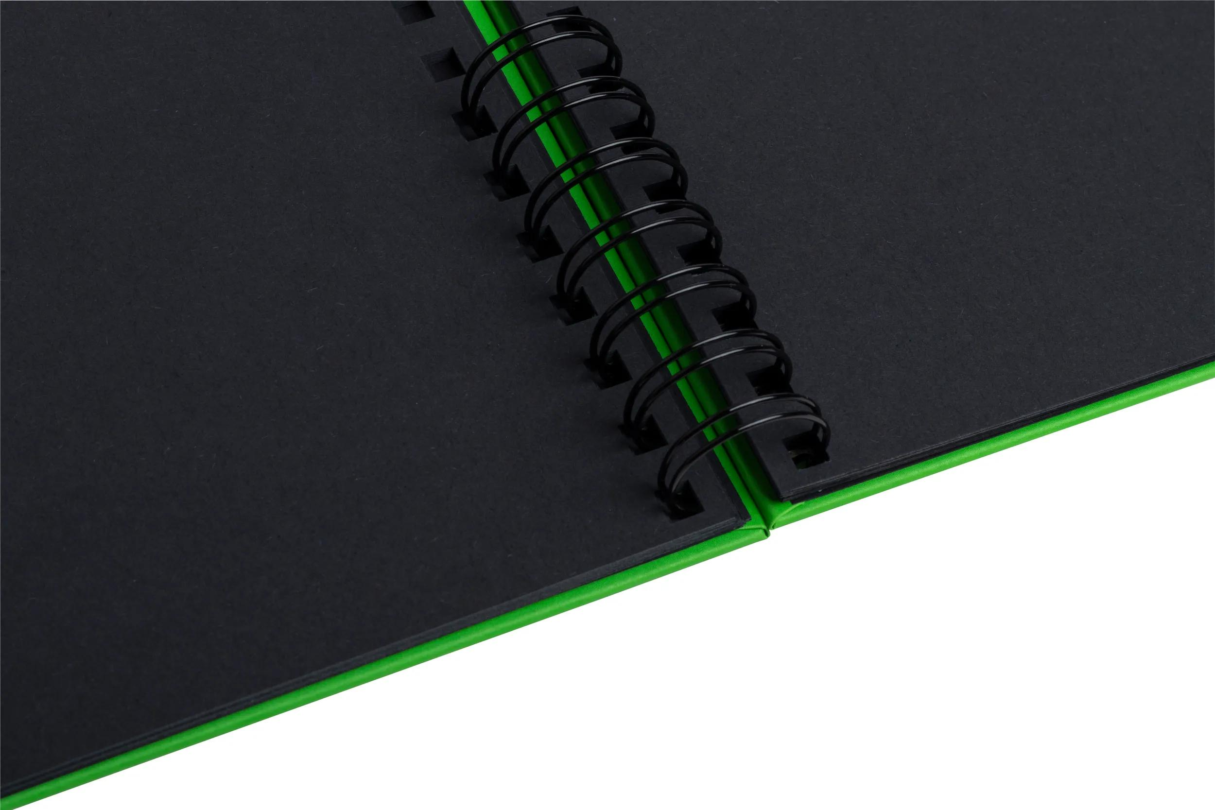 Cuaderno negro con cubierta verde y espiral negra.