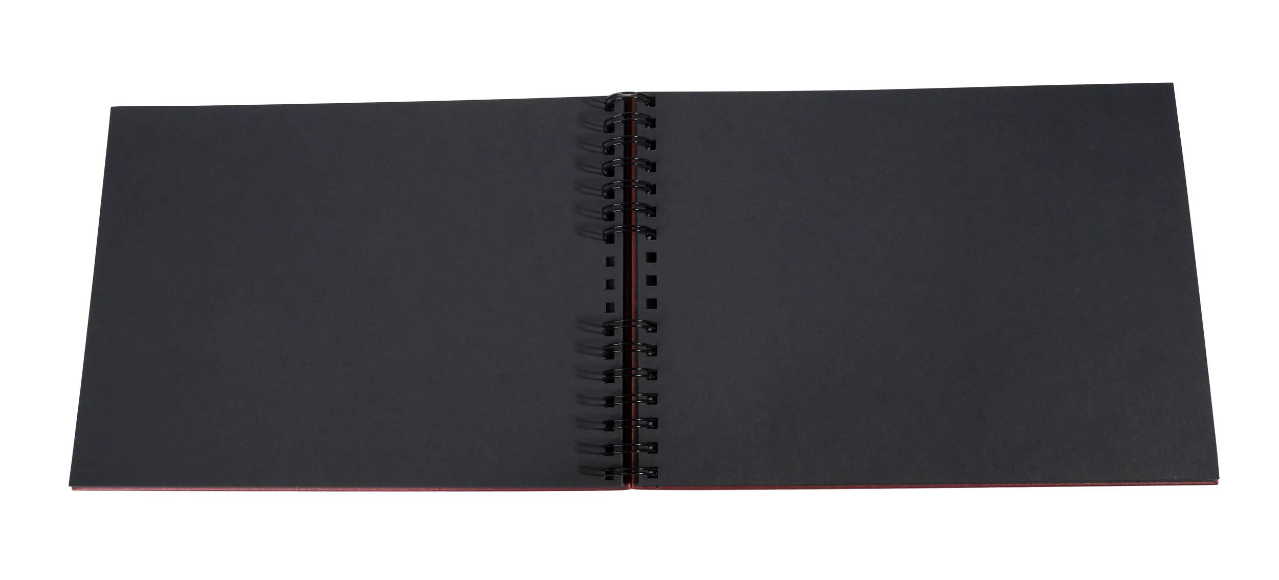 Un cuaderno abierto con páginas negras y encuadernación en espiral.