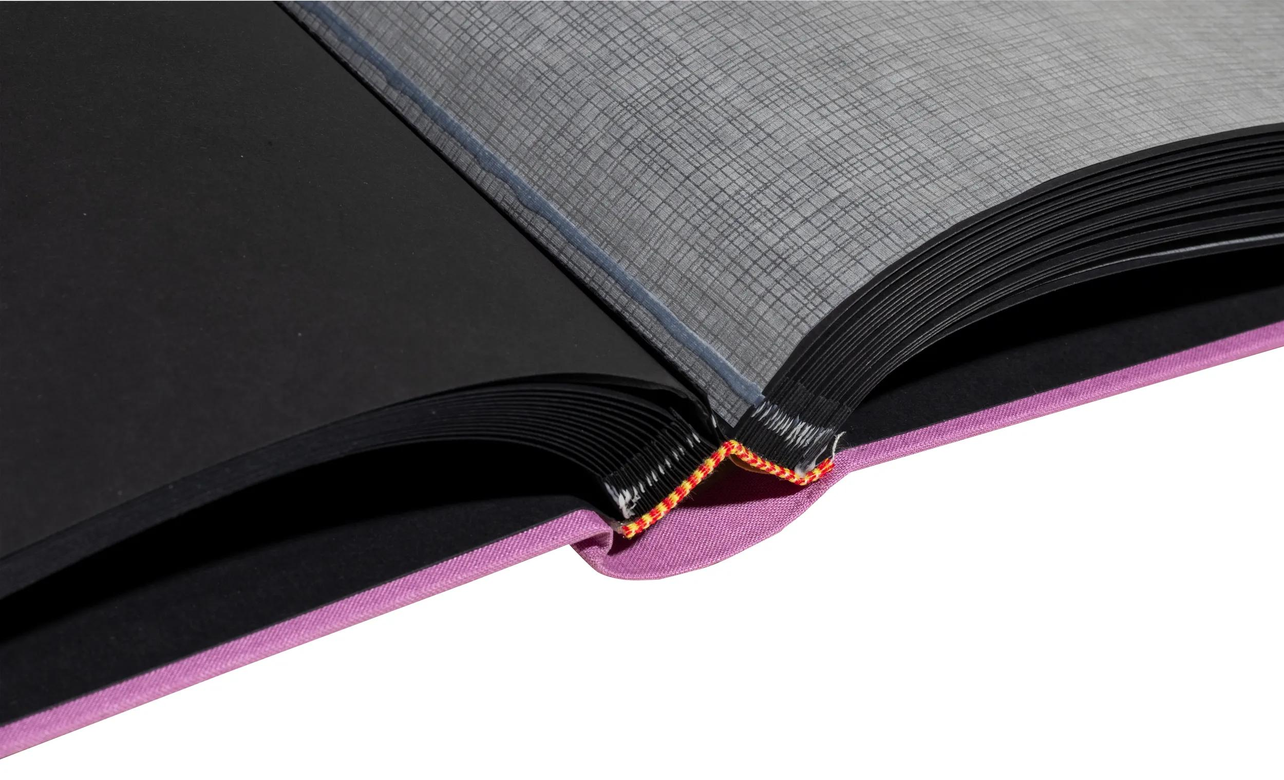 Álbum abierto con páginas negras, portada morada y papel texturizado gris.