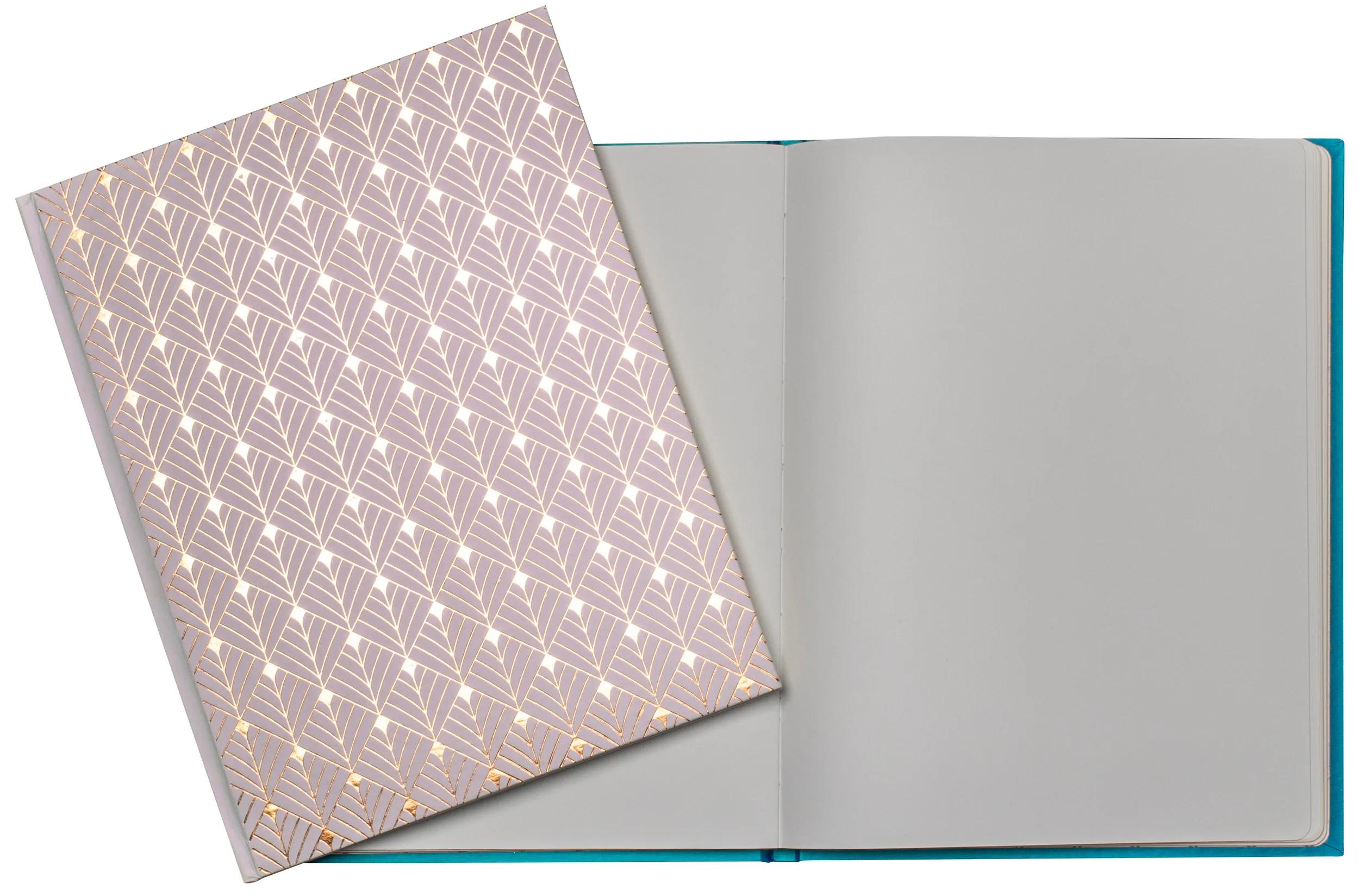 Un cuaderno abierto con tapa turquesa. La página izquierda tiene un patrón.