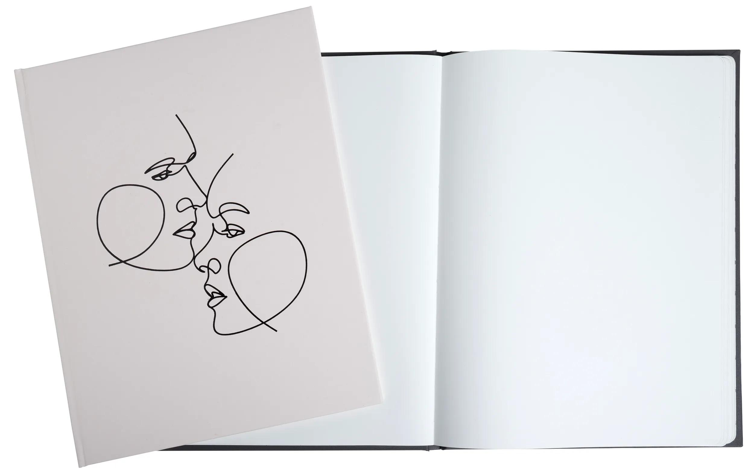 Un cuaderno abierto con tapa negra y una tarjeta con dos caras dibujadas en arte lineal.