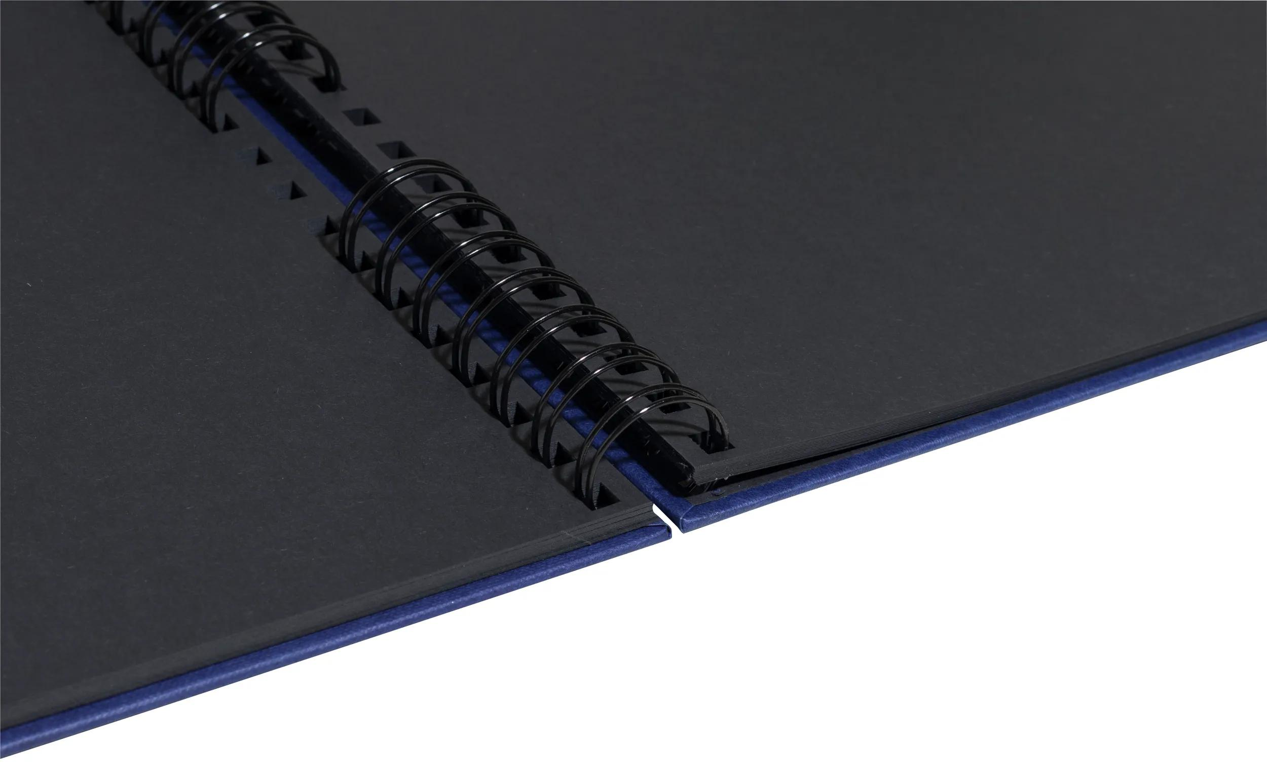 Taccuino blu aperto con spirale nera e pagine nere.