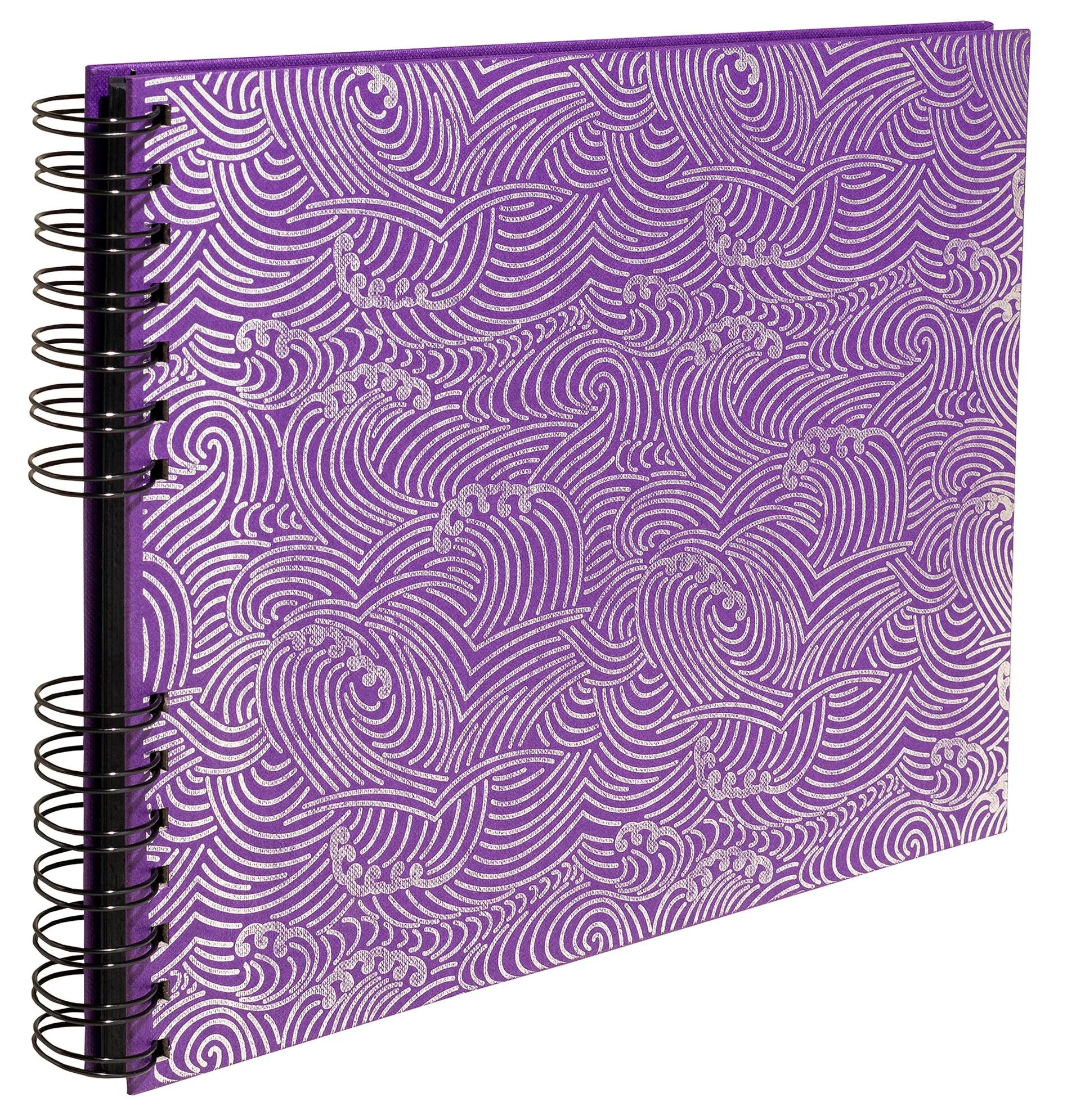 Un cuaderno morado con espiral y diseño de olas plateadas.