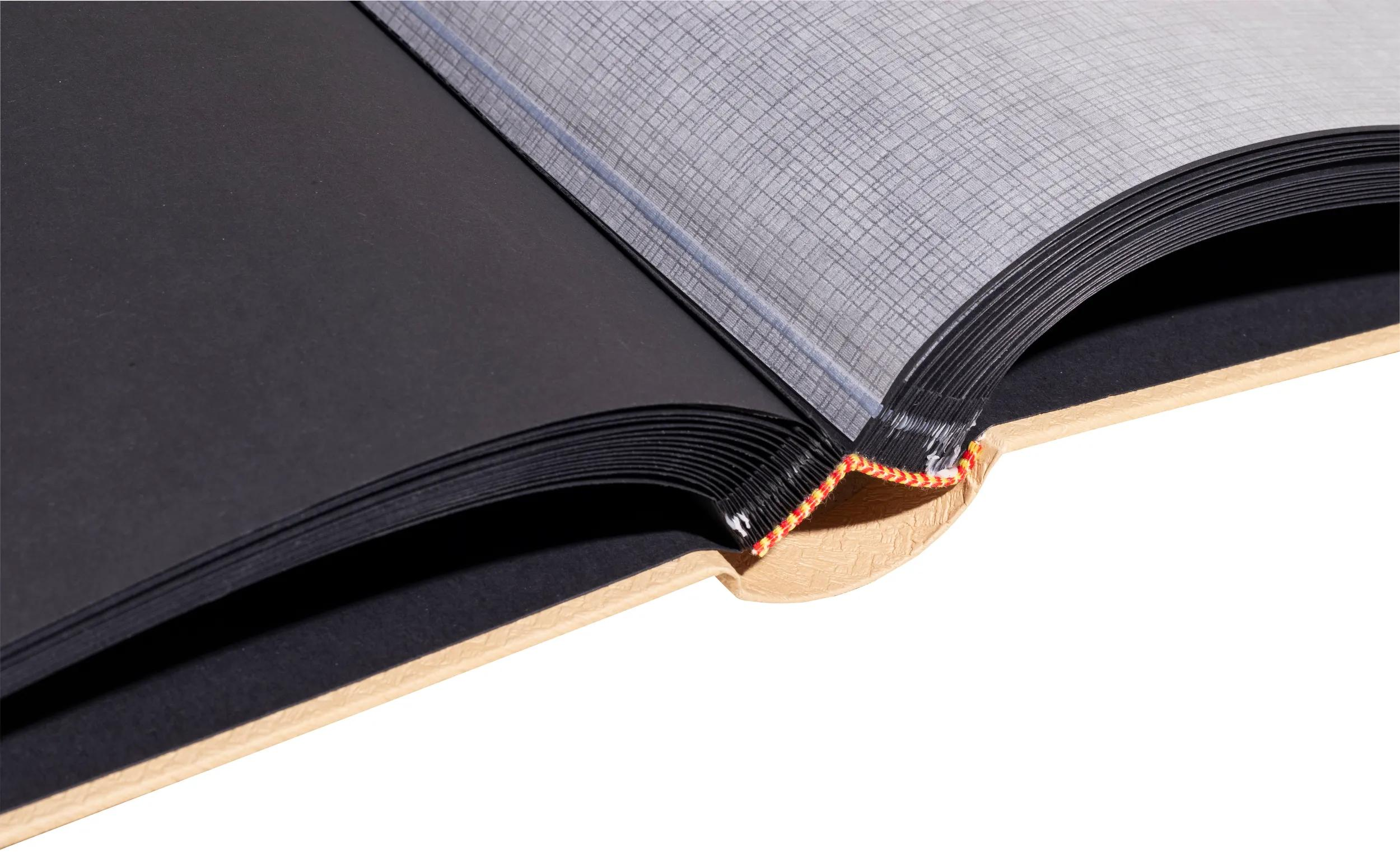 Un libro abierto con páginas negras y una hoja protectora estampada.