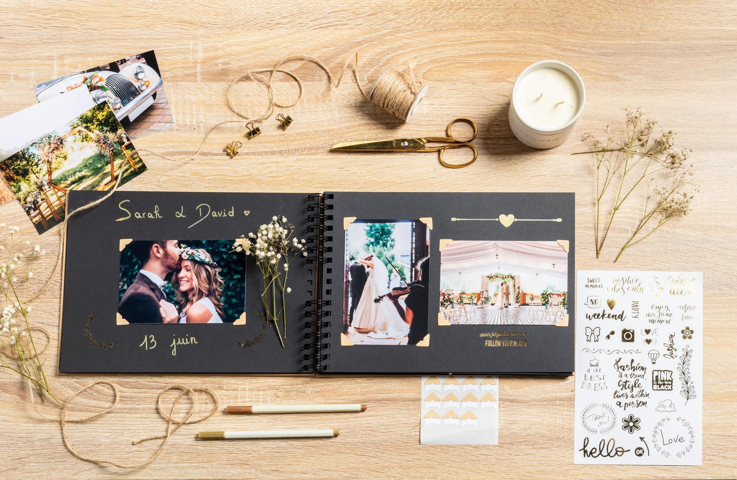 Álbum de bodas con fotos, cuerda, vela, tijeras y decoraciones sobre fondo de madera.