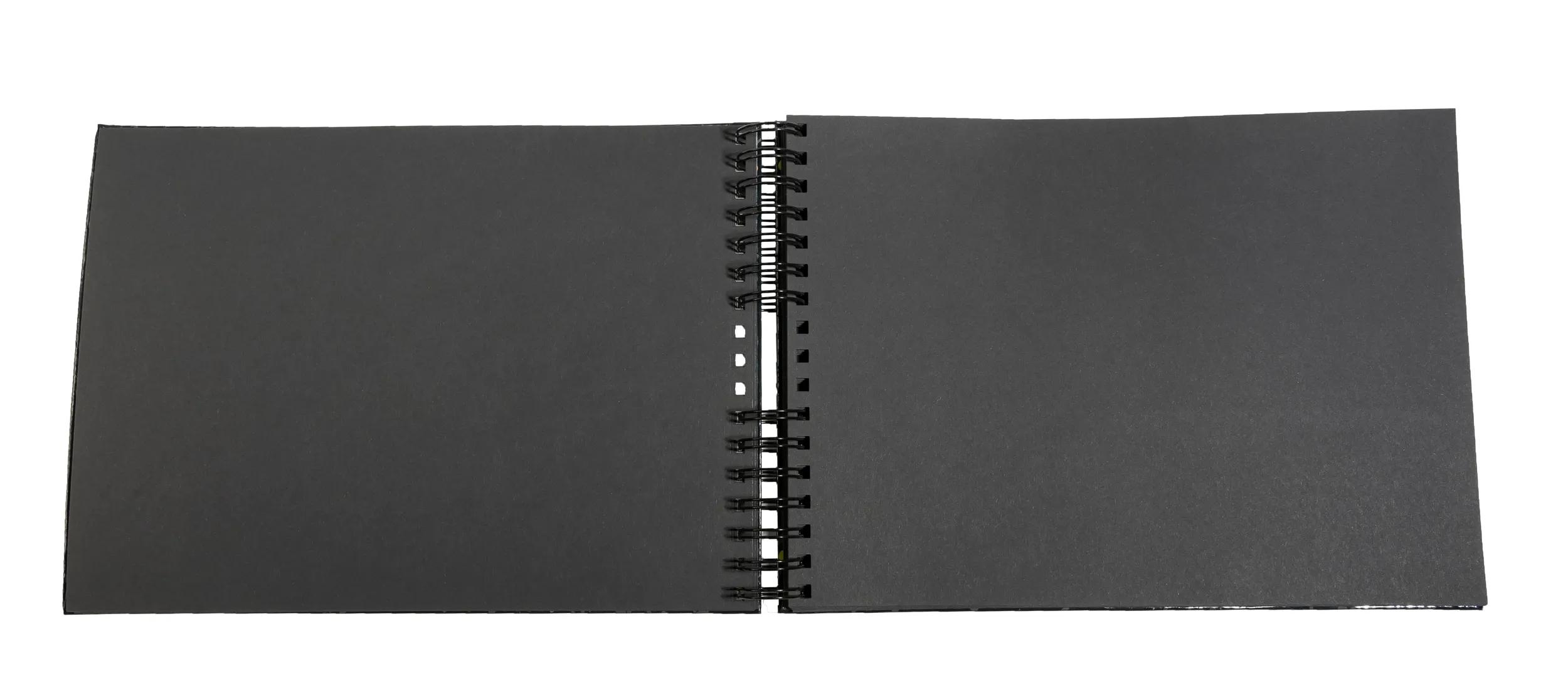 Un cuaderno negro abierto con espiral, aislado sobre fondo blanco.
