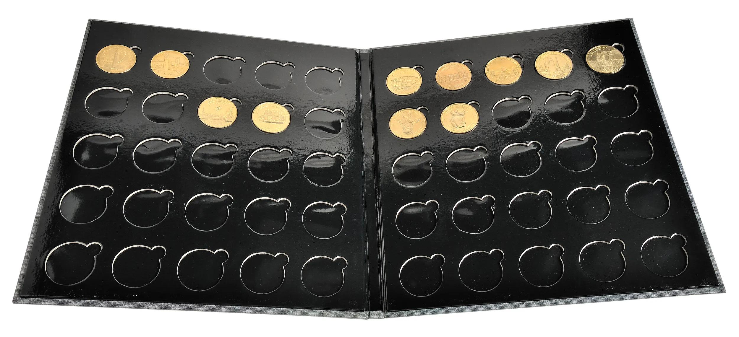 Un álbum negro muestra varias monedas de oro en recortes circulares.