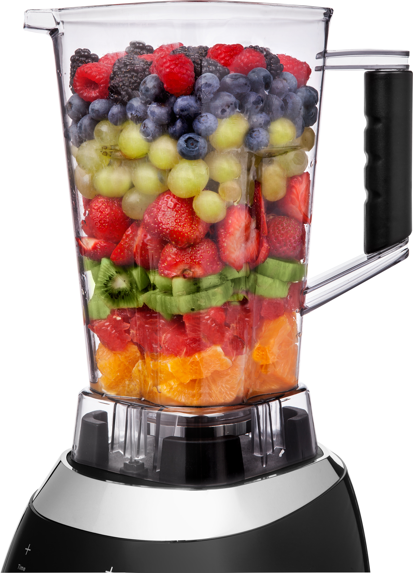 A blender filled with layered fruits: berries, grapes, strawberries, kiwi, grapefruit, and orange.
