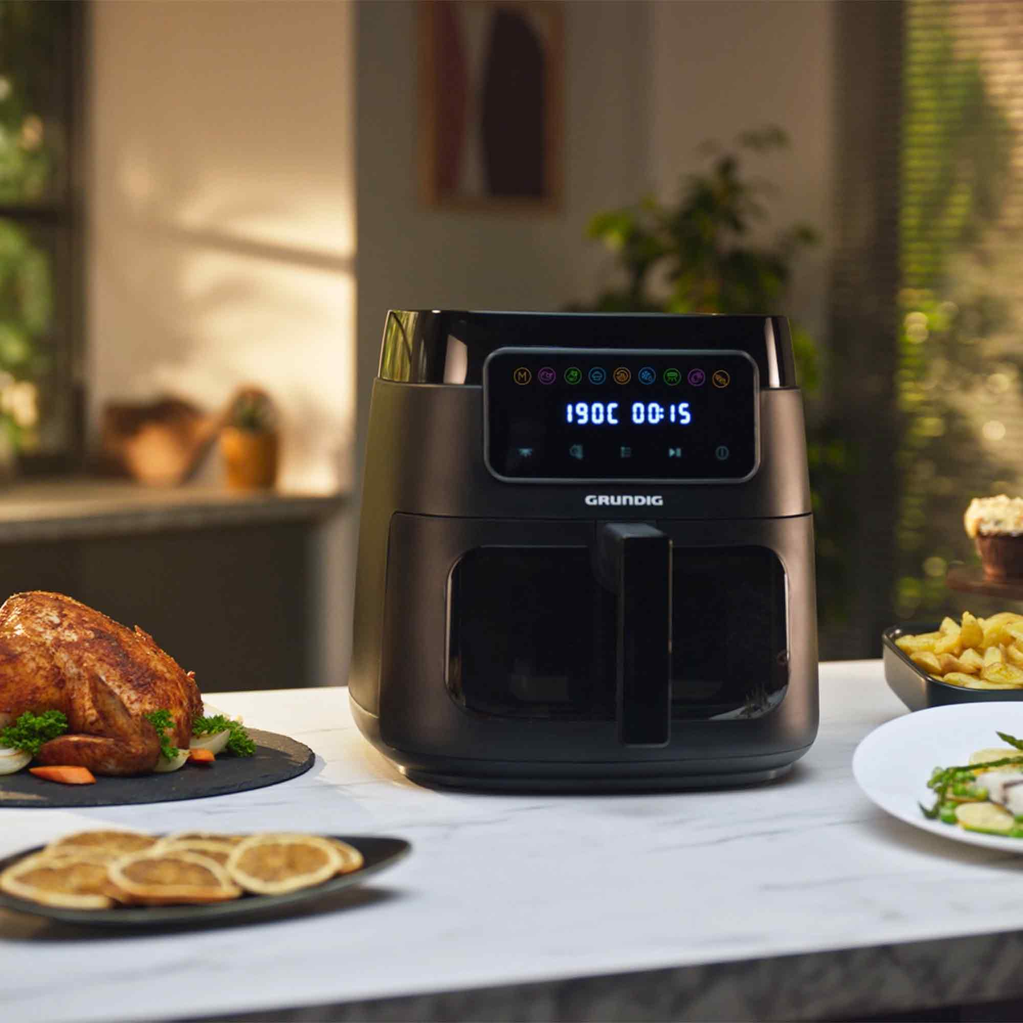 Czarna frytkownica beztłuszczowa z pieczonym kurczakiem i dodatkami.