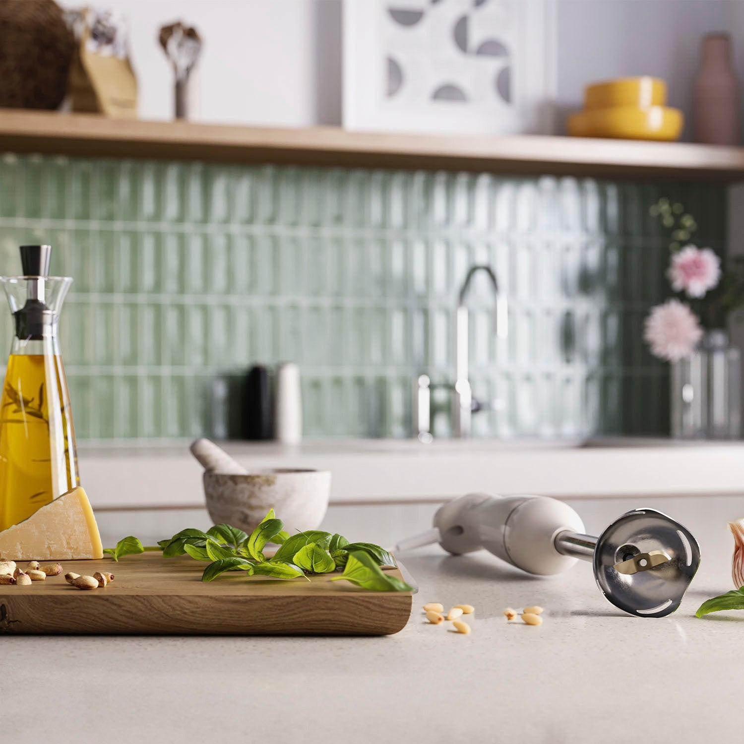 Blender ręczny leży na blacie obok składników takich jak bazylia i parmezan.