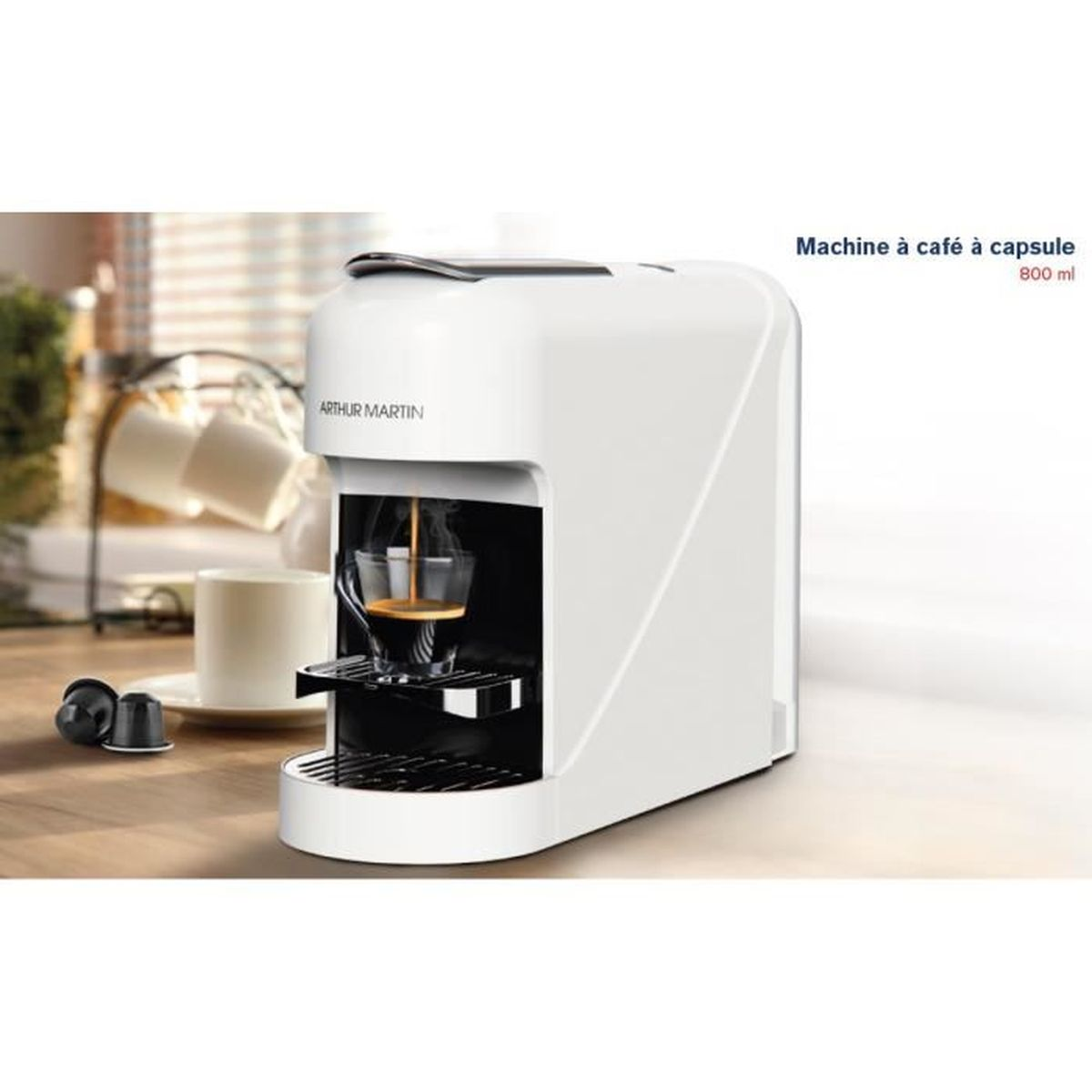 Weiße Kapselkaffeemaschine mit einem Krug und Kaffeekapseln im Vordergrund.