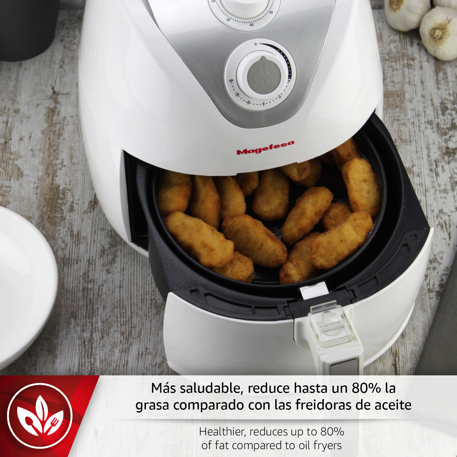 Freidora de aire blanca con croquetas doradas y ajos al fondo.