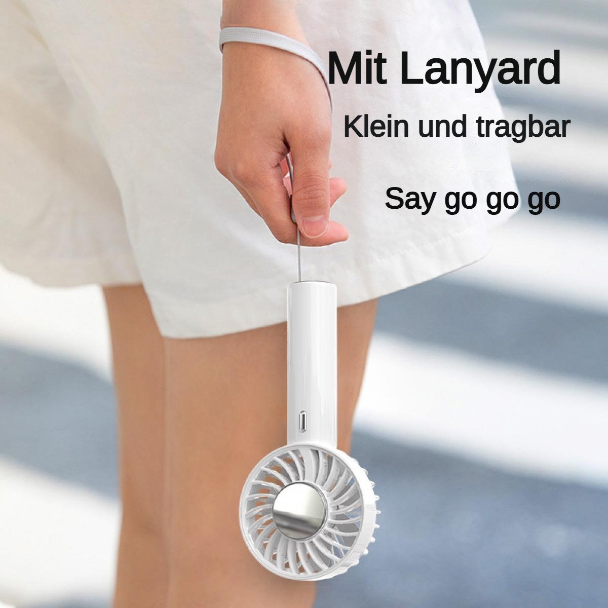 Eine Hand hält einen kleinen weißen Ventilator mit Lanyard.