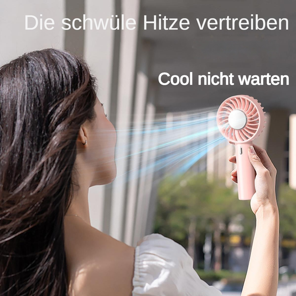 Eine Frau hält einen rosa Ventilator, der kühle Luft bläst.