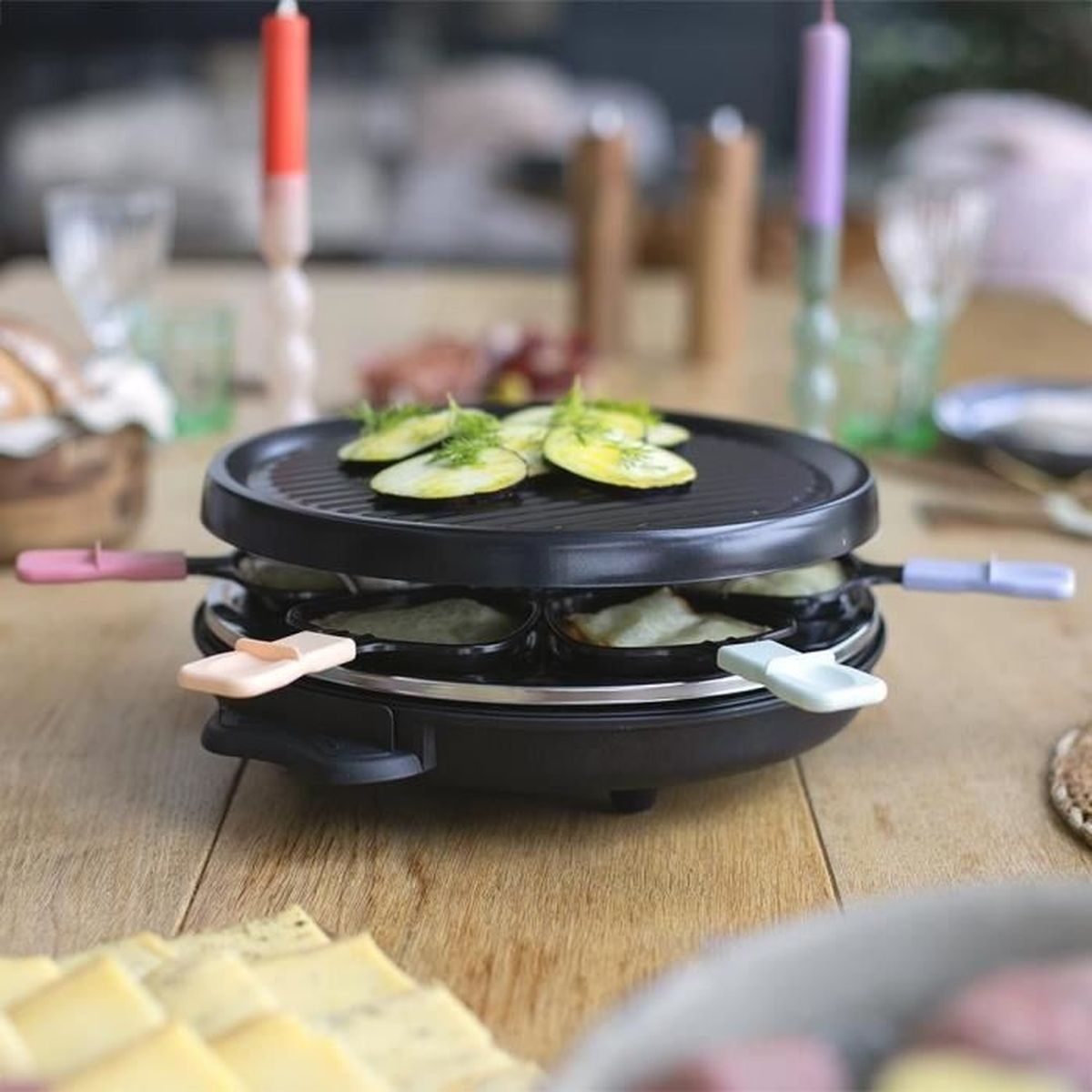 Ein Raclette-Grill mit Kartoffeln und Gurken auf dem Tisch.