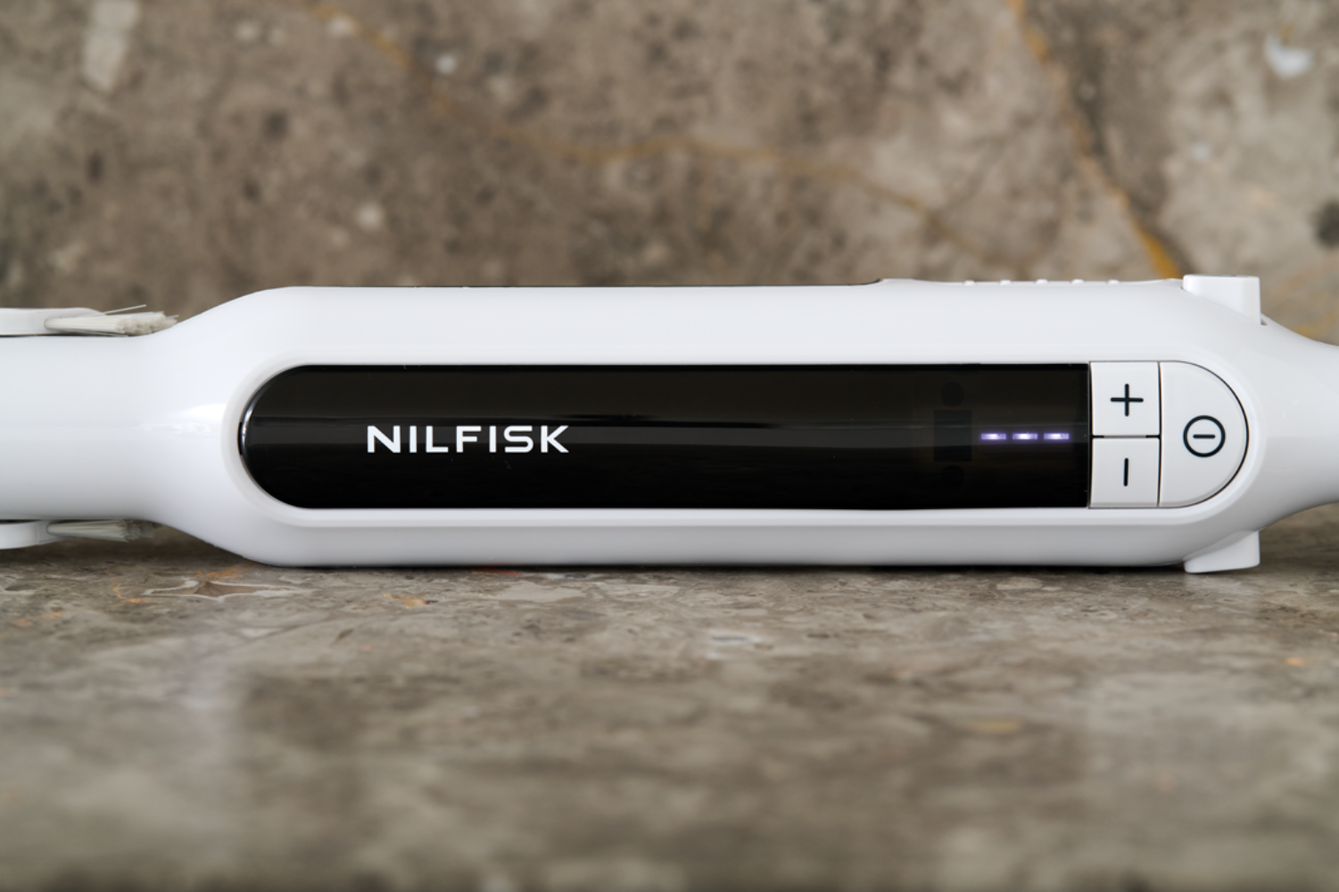 Gros plan d'un appareil Nilfisk blanc avec écran noir et commandes.