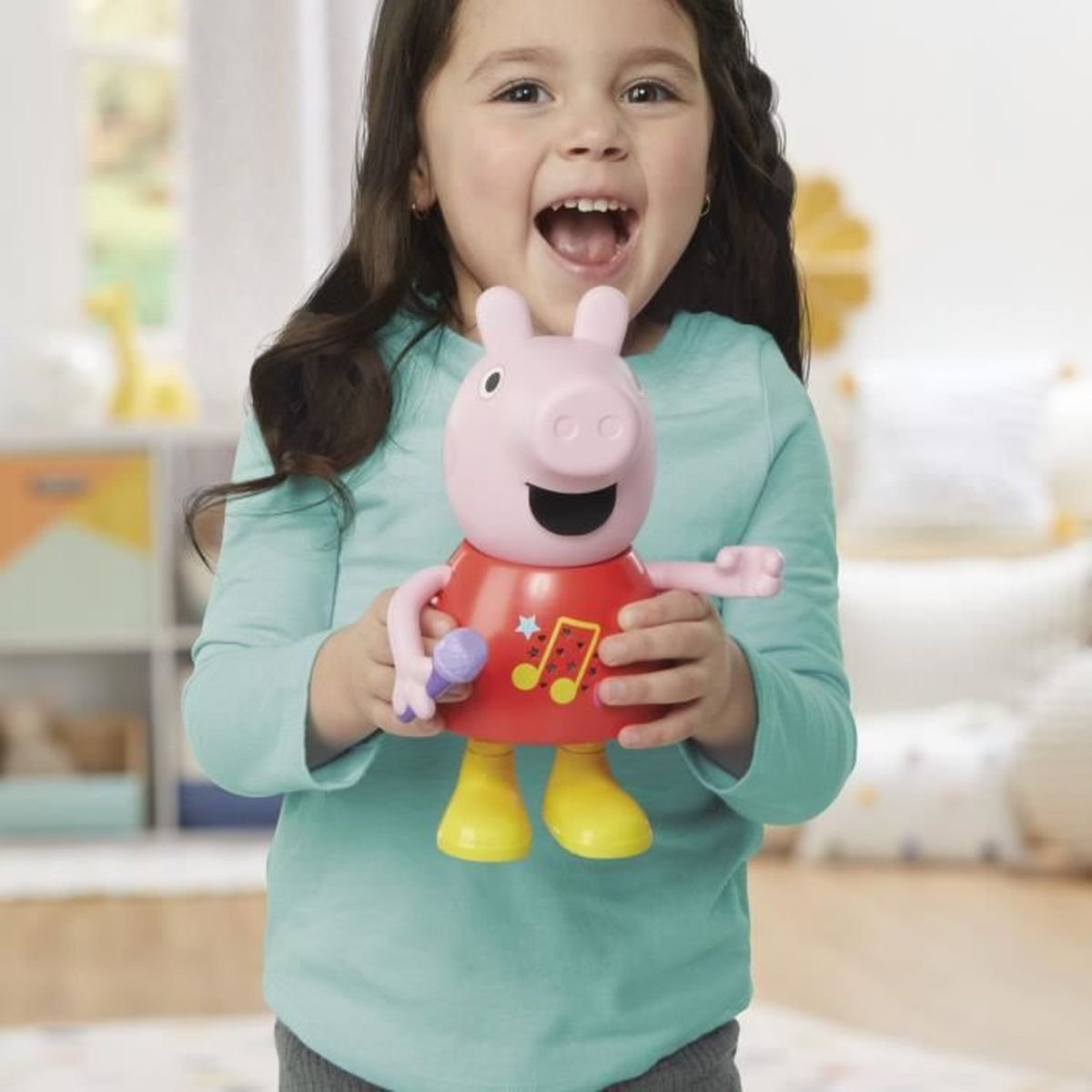 Ein Mädchen hält eine rosa Peppa Wutz Figur mit Mikrofon und gelben Stiefeln.