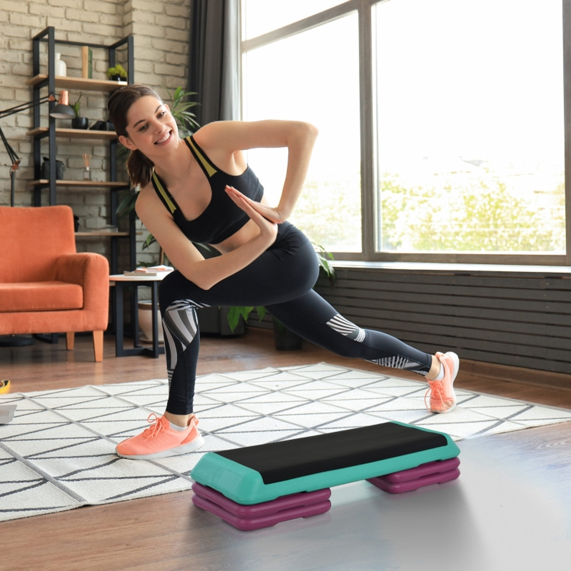 Frau in Sportkleidung macht eine Ausfallschritt-Übung neben einem Aerobic-Stepper.
