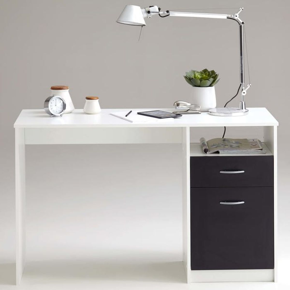 Ein weißer Schreibtisch mit silberner Schreibtischlampe, Uhr, Pflanzen und Schubladen.