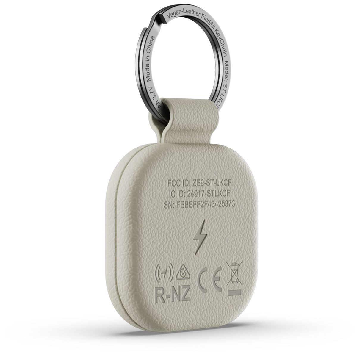 Ein beiger Schlüsselanhänger aus veganem Leder mit silbernem Ring. Textdetails FCC ID und SN.