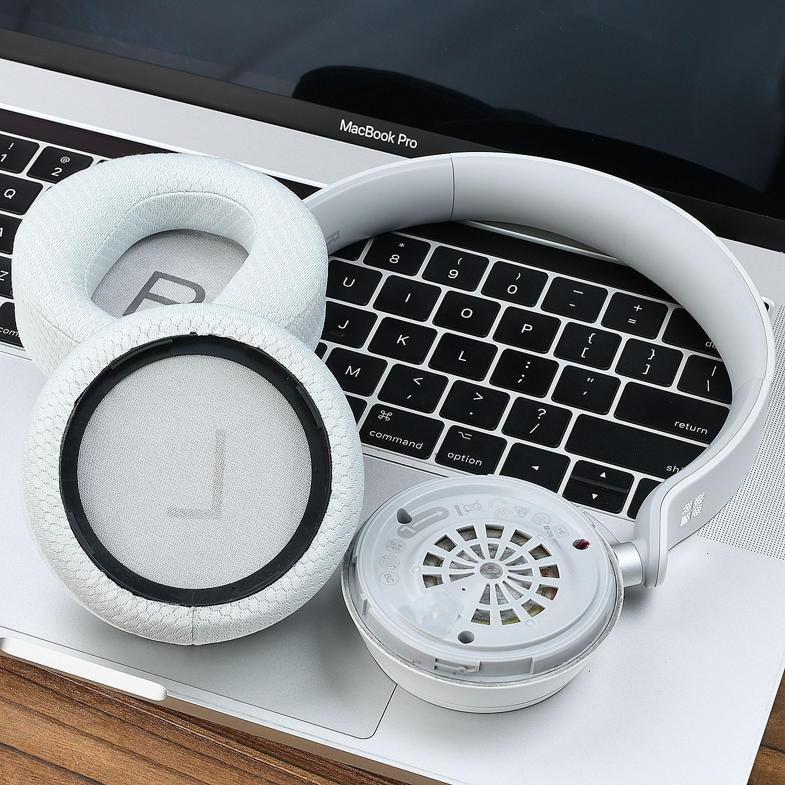Weiße Kopfhörer liegen auf einer MacBook-Tastatur.