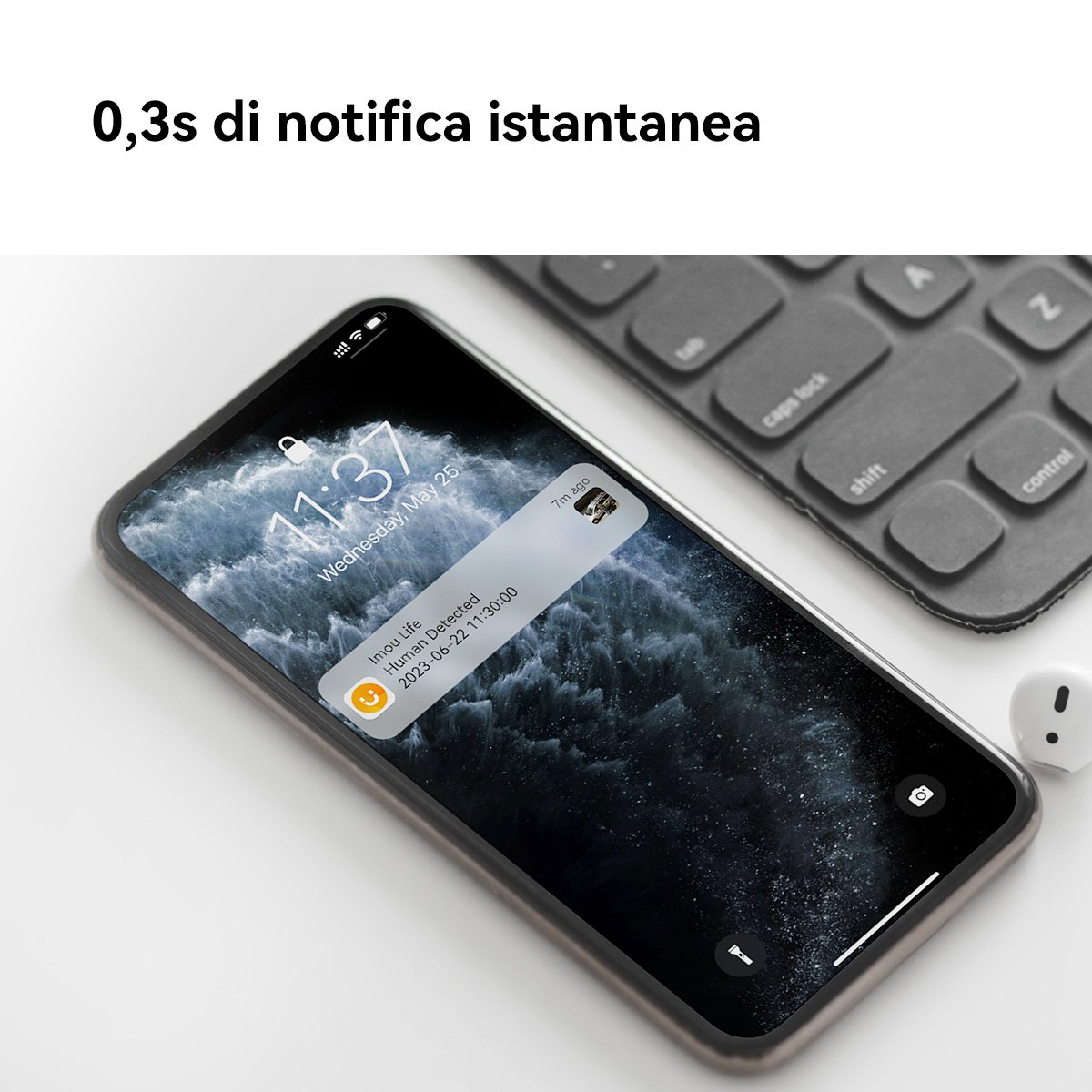 Smartfon wyświetla powiadomienie "Human Detected". Obok leży klawiatura.