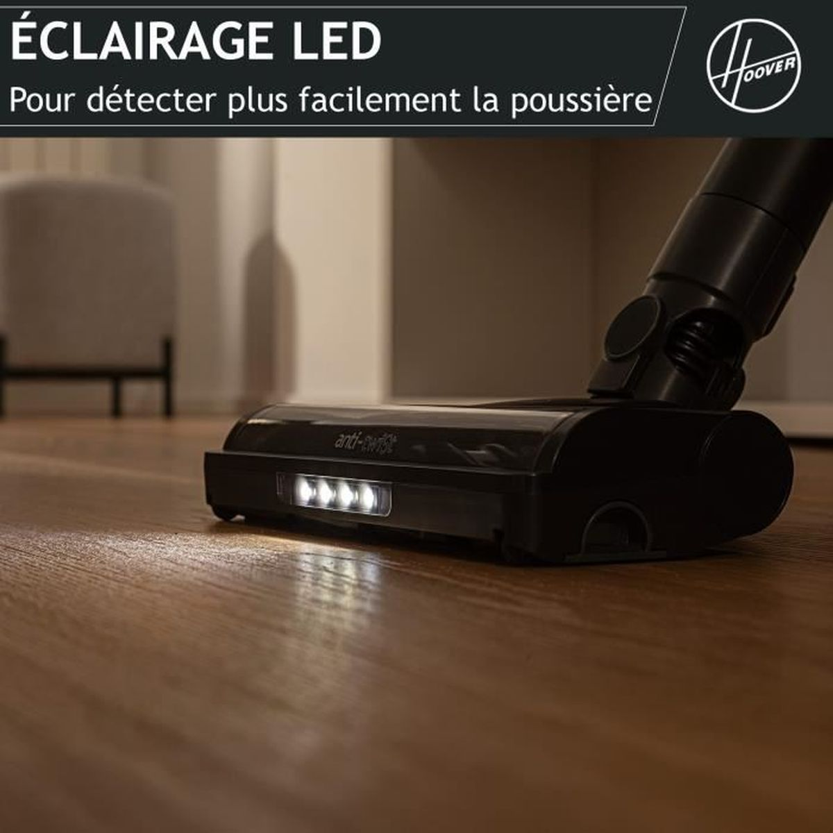 Testata aspirapolvere nera con luci LED su pavimento in legno.