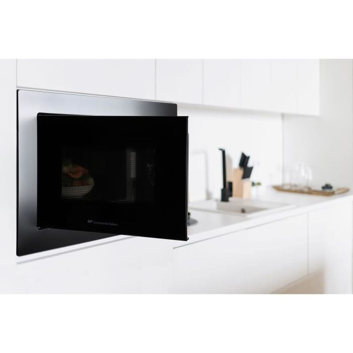 Microondas empotrado negro con puerta abierta, junto a un fregadero.