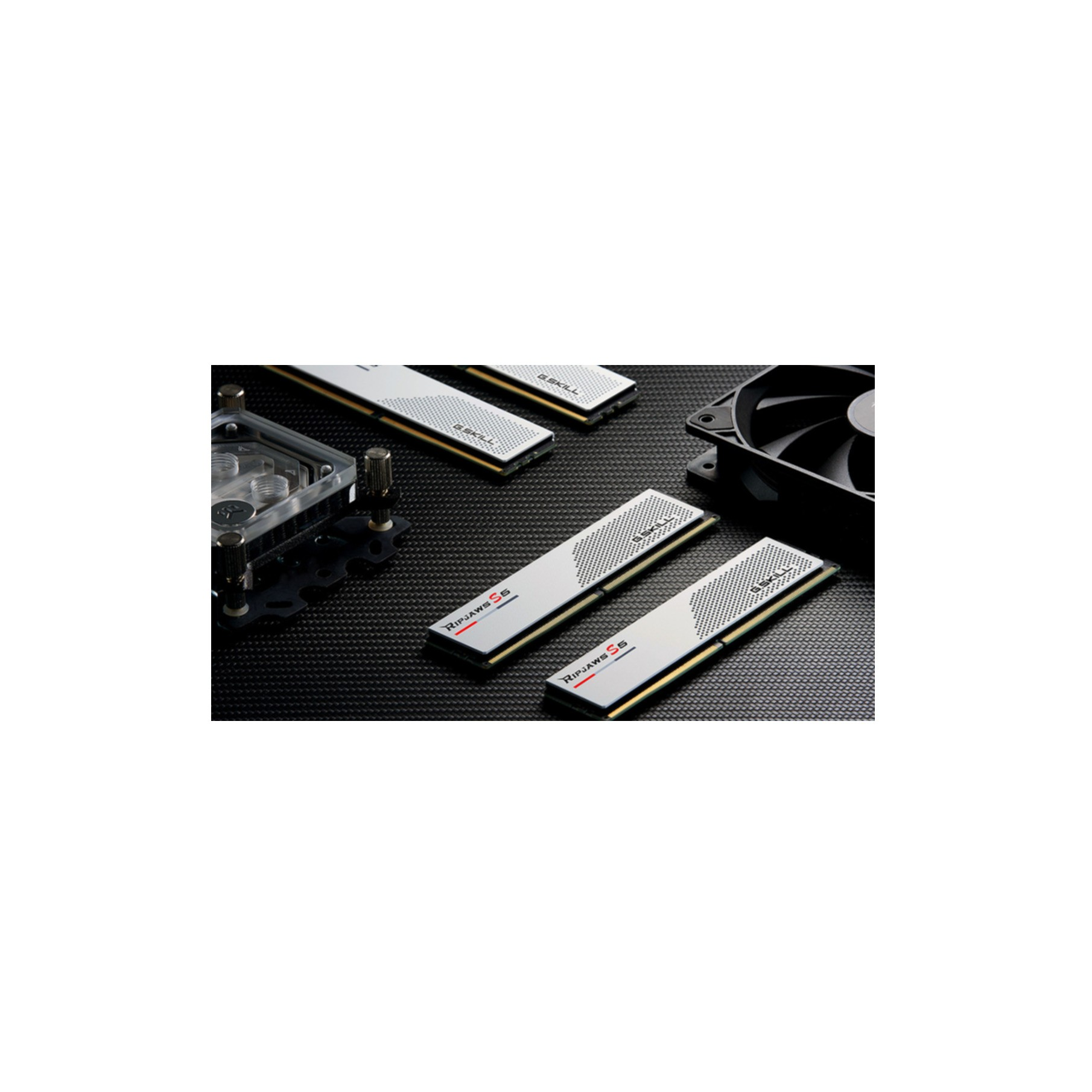 Moduły RAM komputera, blok chłodzenia wodnego i wentylator na czarnej powierzchni.