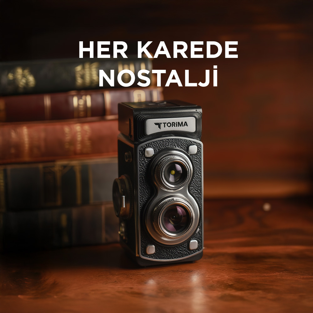 Eski bir kamera, ahşap bir masanın üzerindeki eski kitapların yanında duruyor.
