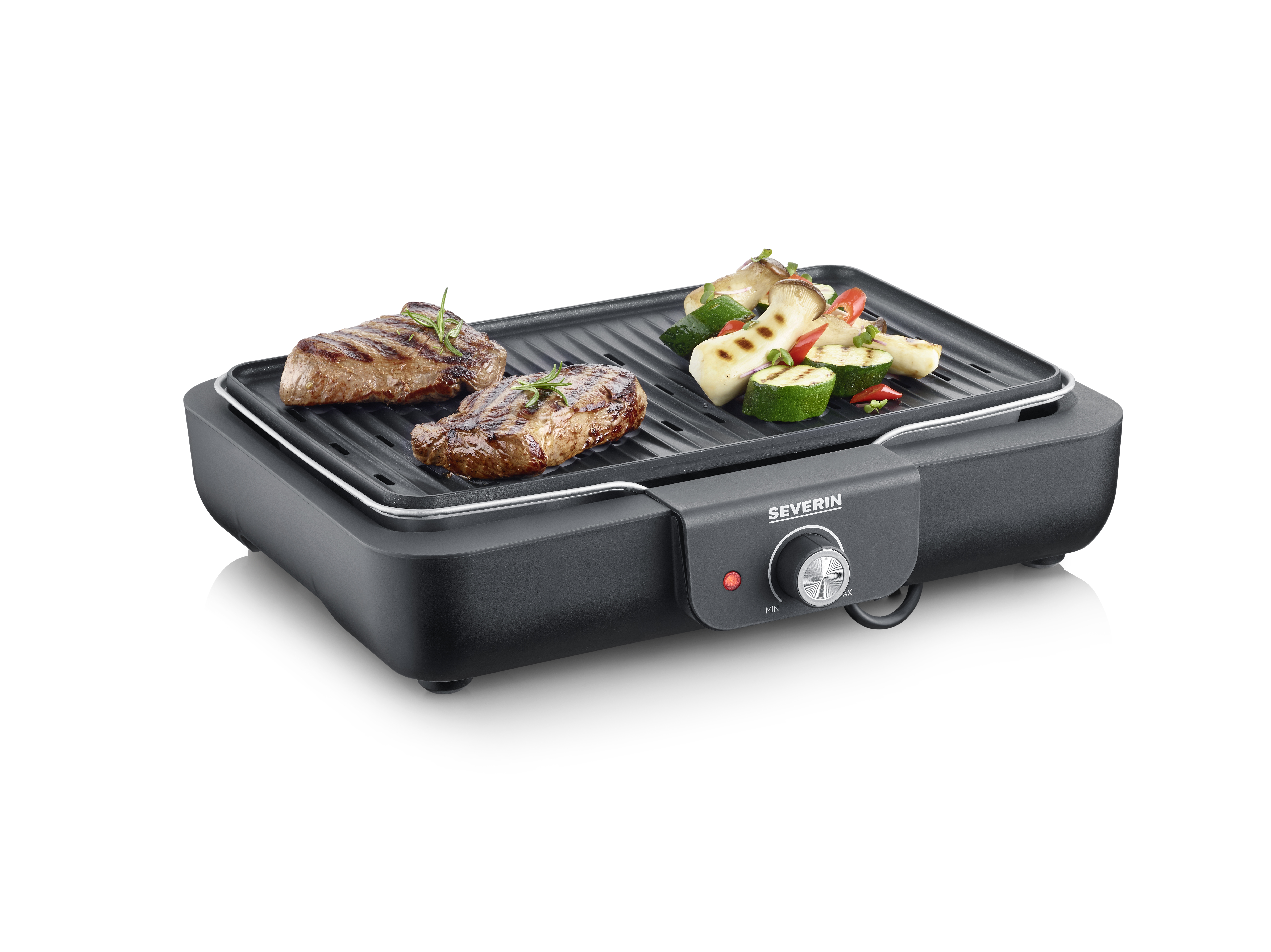 An electric grill with two steaks and grilled vegetables.