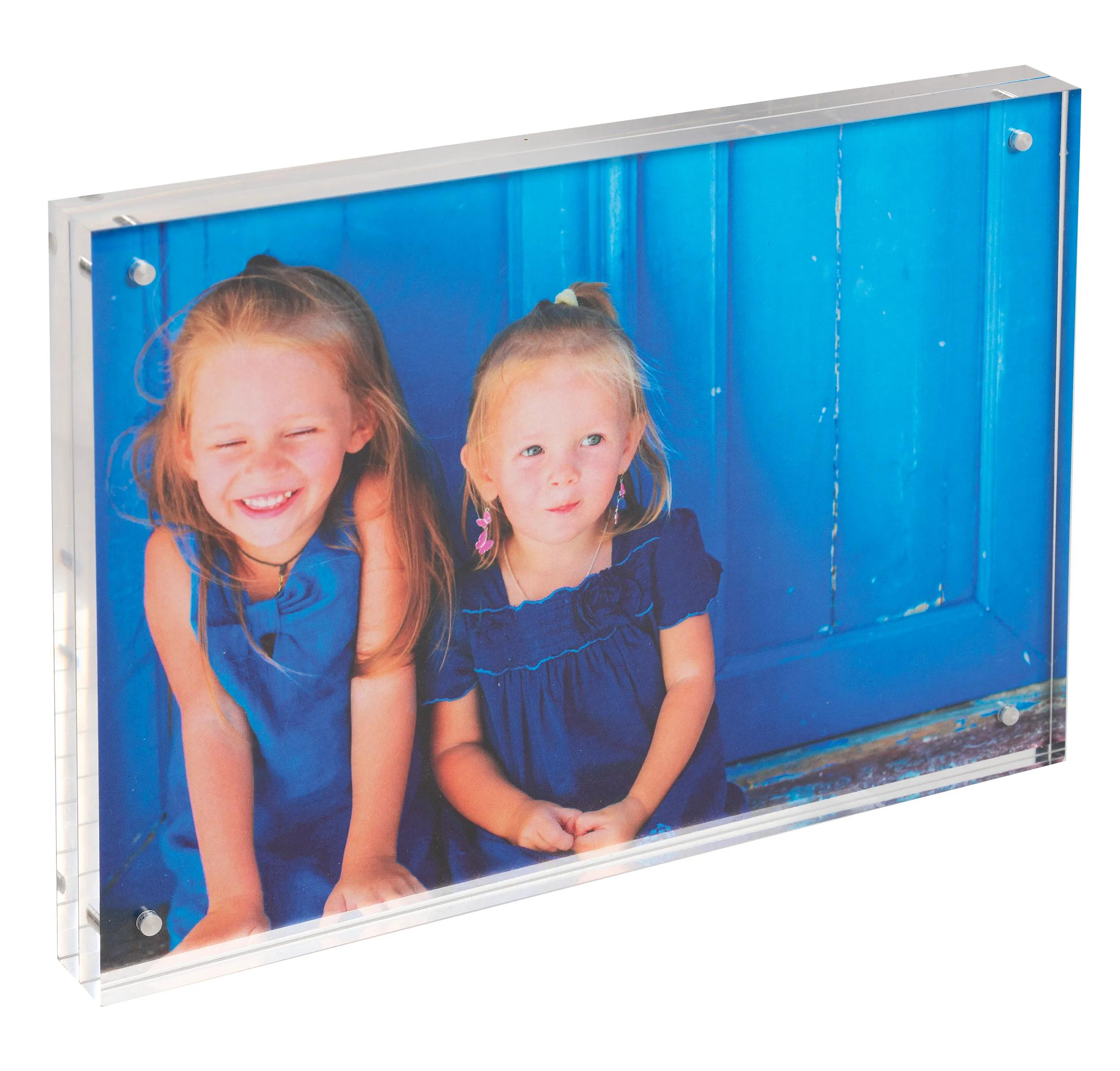 Dos niñas con vestidos azules delante de una puerta azul.