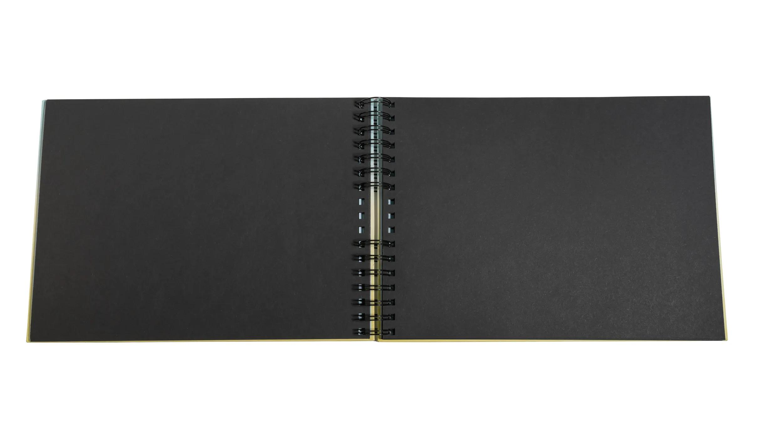 Un cuaderno abierto con páginas negras y encuadernación en espiral.