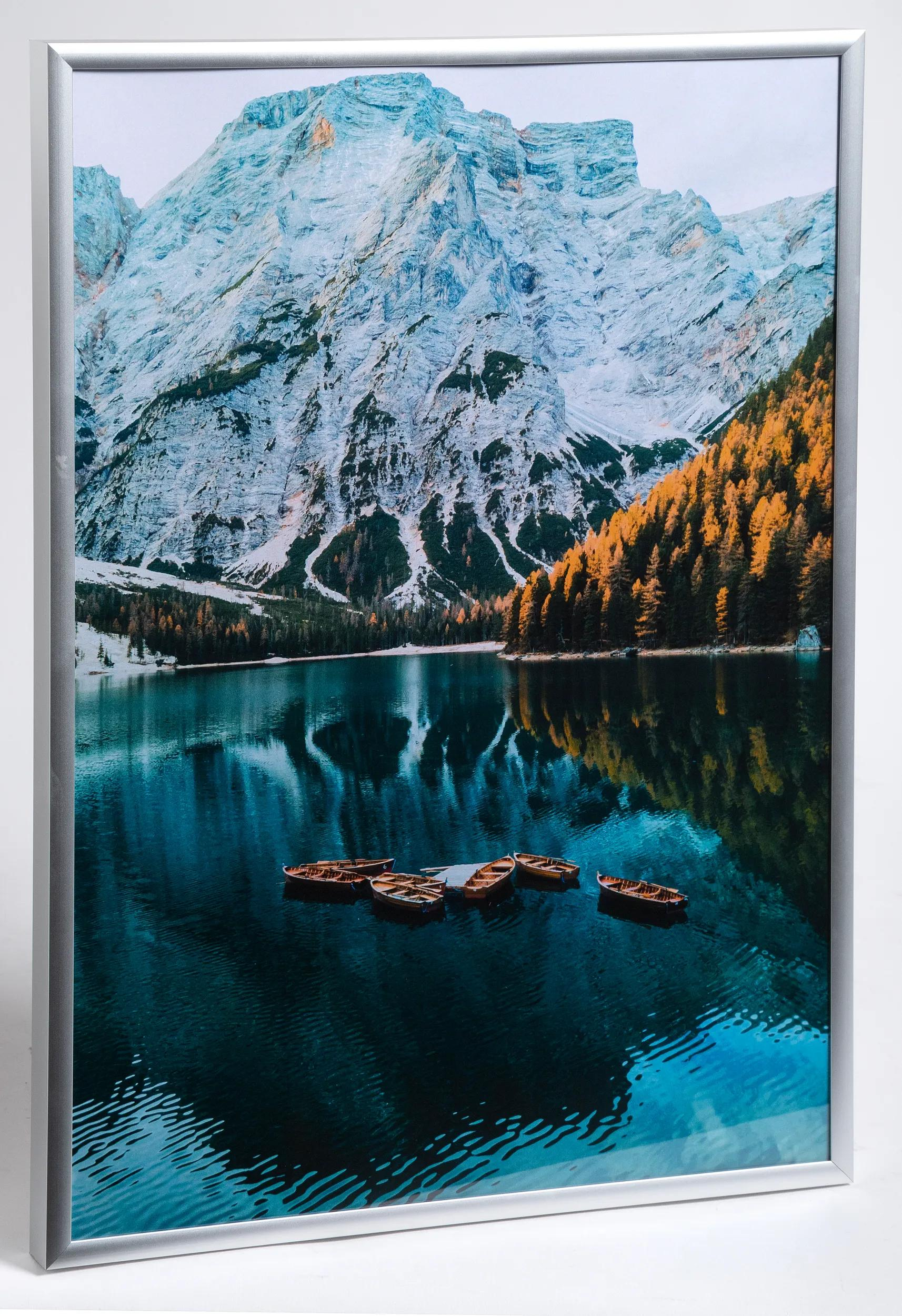 Botes de madera en un lago tranquilo con montañas y árboles al fondo.