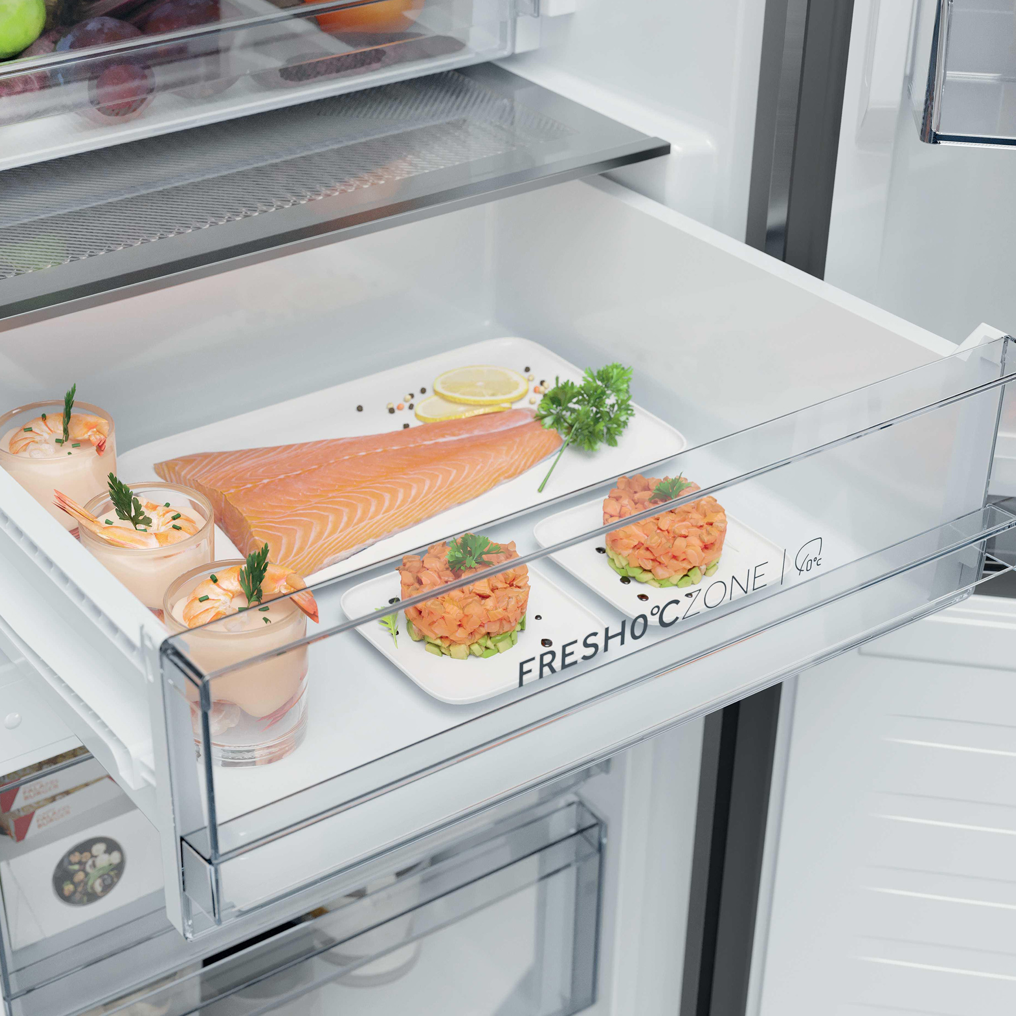 Gefrierschublade mit Lachsfilet, Garnelen-Cocktails, Lachs-Tatar und Avocado.