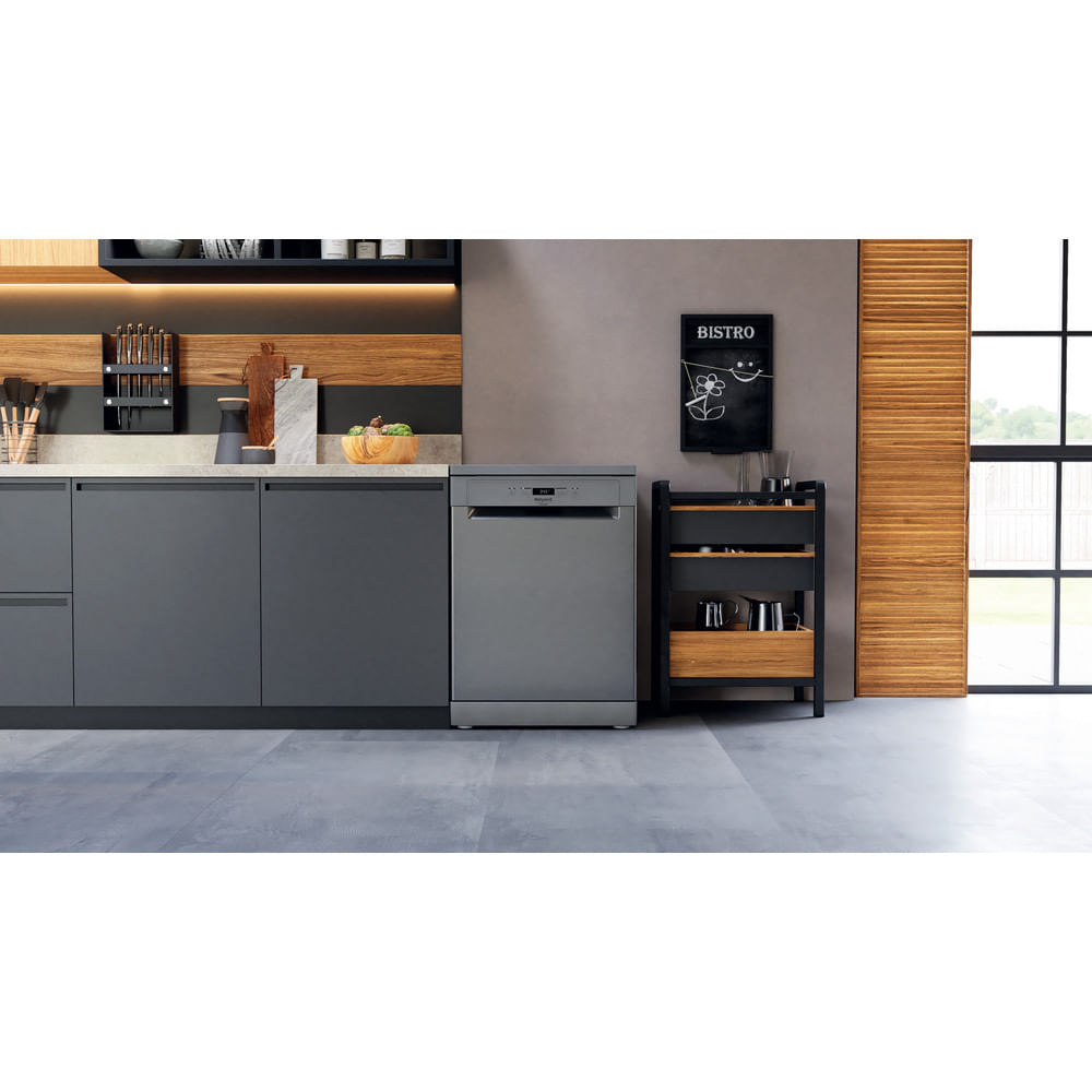 Cucina grigia con lavastoviglie, carrello e pannellatura in legno.