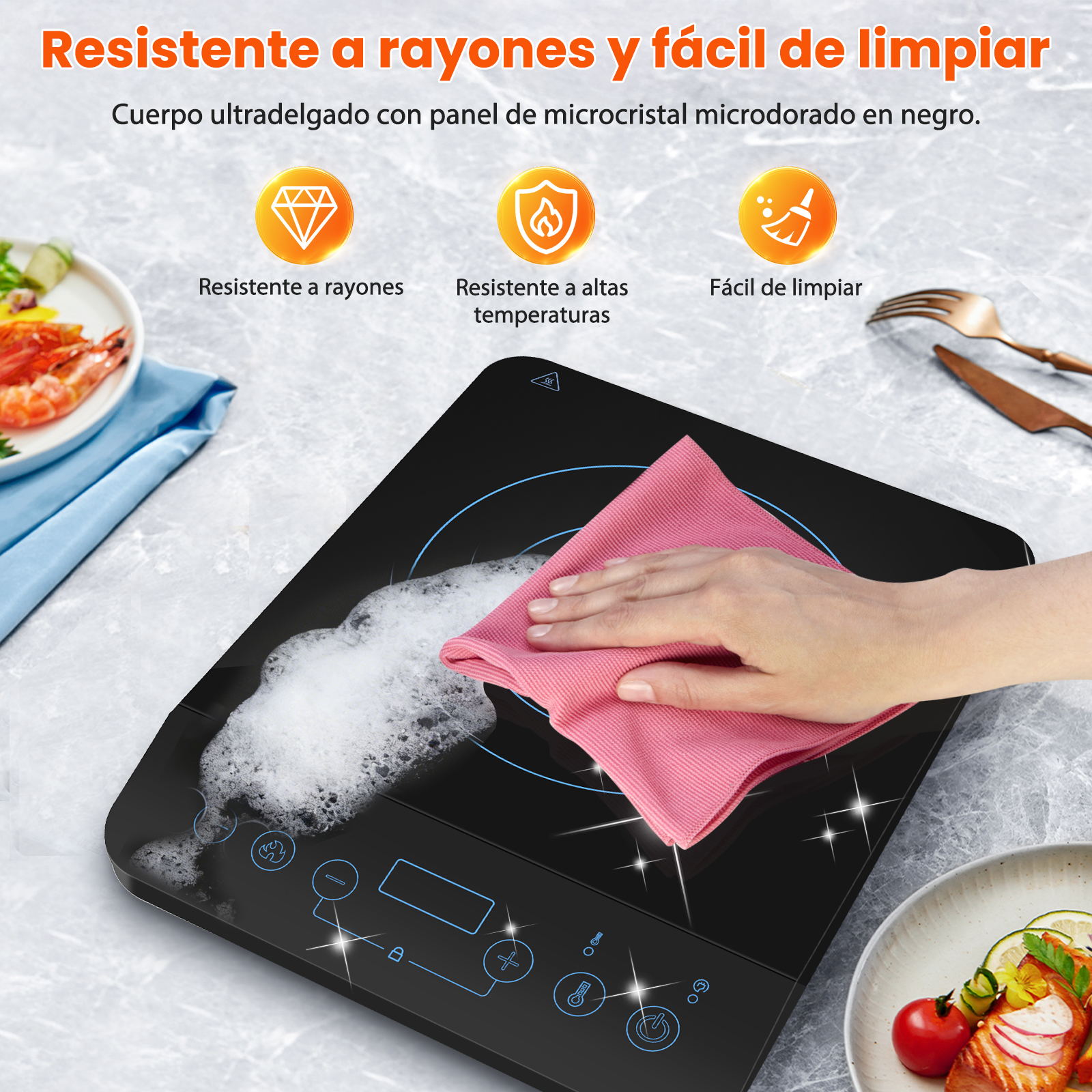 Una mano limpia una placa de inducción negra con un paño rosa y espuma.