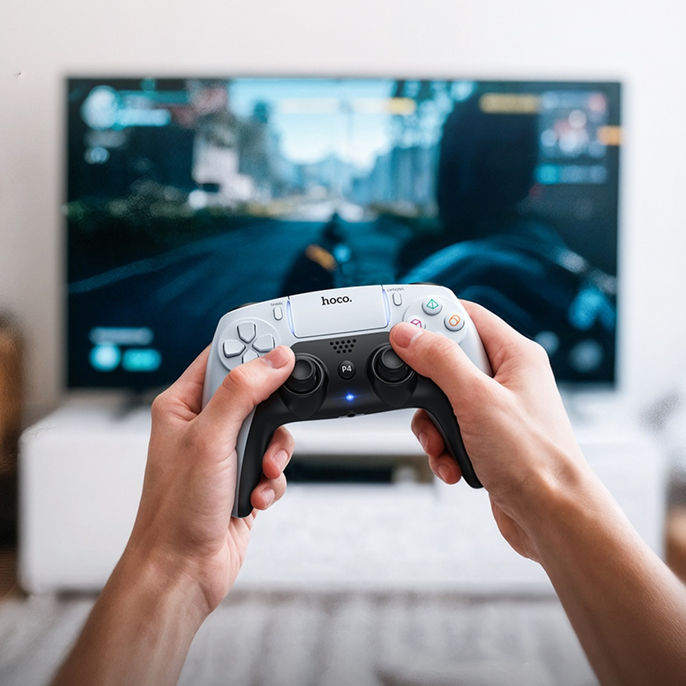 Manos sujetan un mando blanco frente a una pantalla de TV con un videojuego.