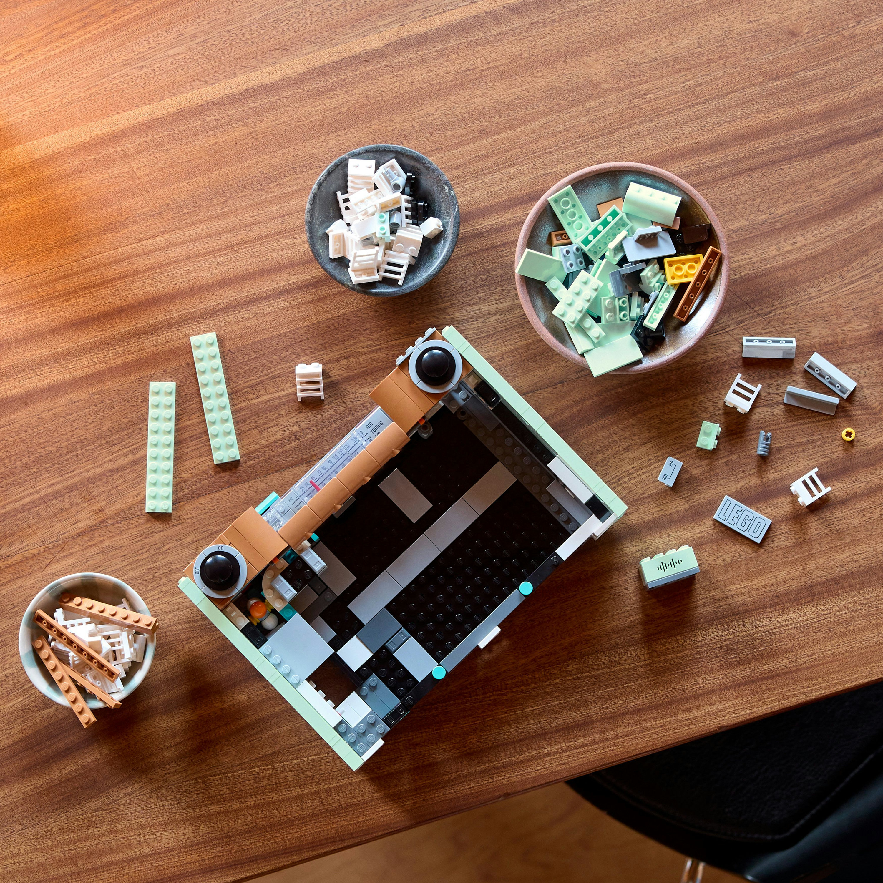 Klocki Lego składane są w radio, na drewnianym stole.