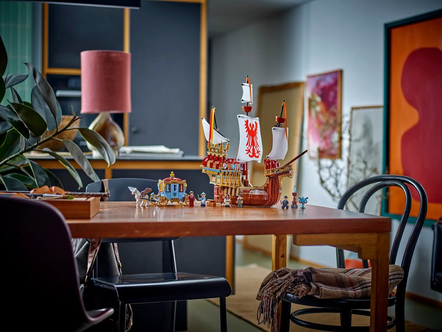 Statek i karoca Lego stoją na drewnianym stole.