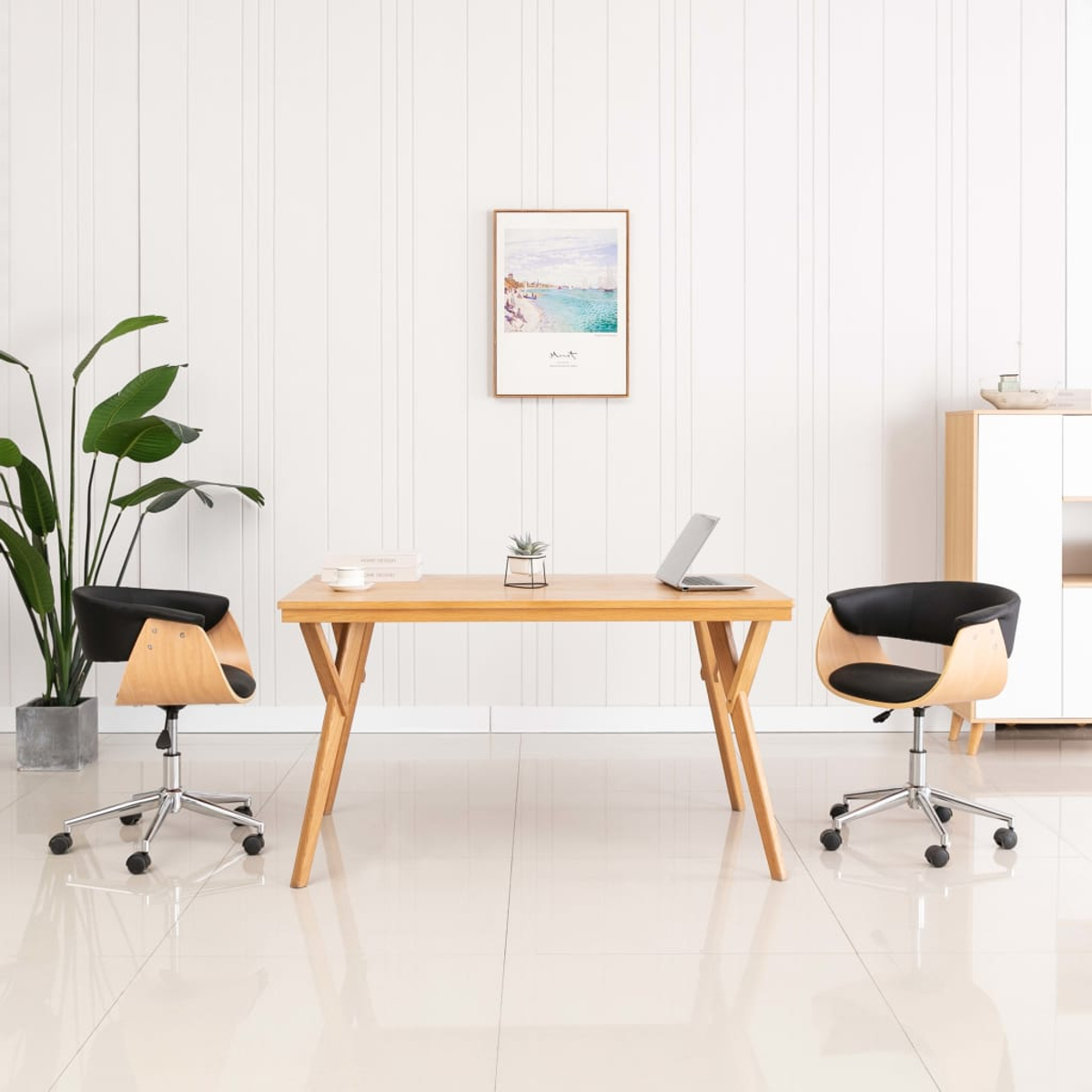 Modernes Büro mit Holztisch, zwei schwarzen Stühlen, Pflanze und gerahmtem Strandbild.