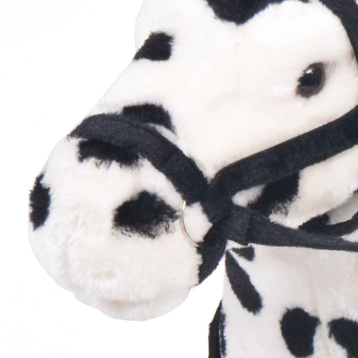 Ein Plüschpferd mit schwarzen Flecken und einem schwarzen Zaumzeug.