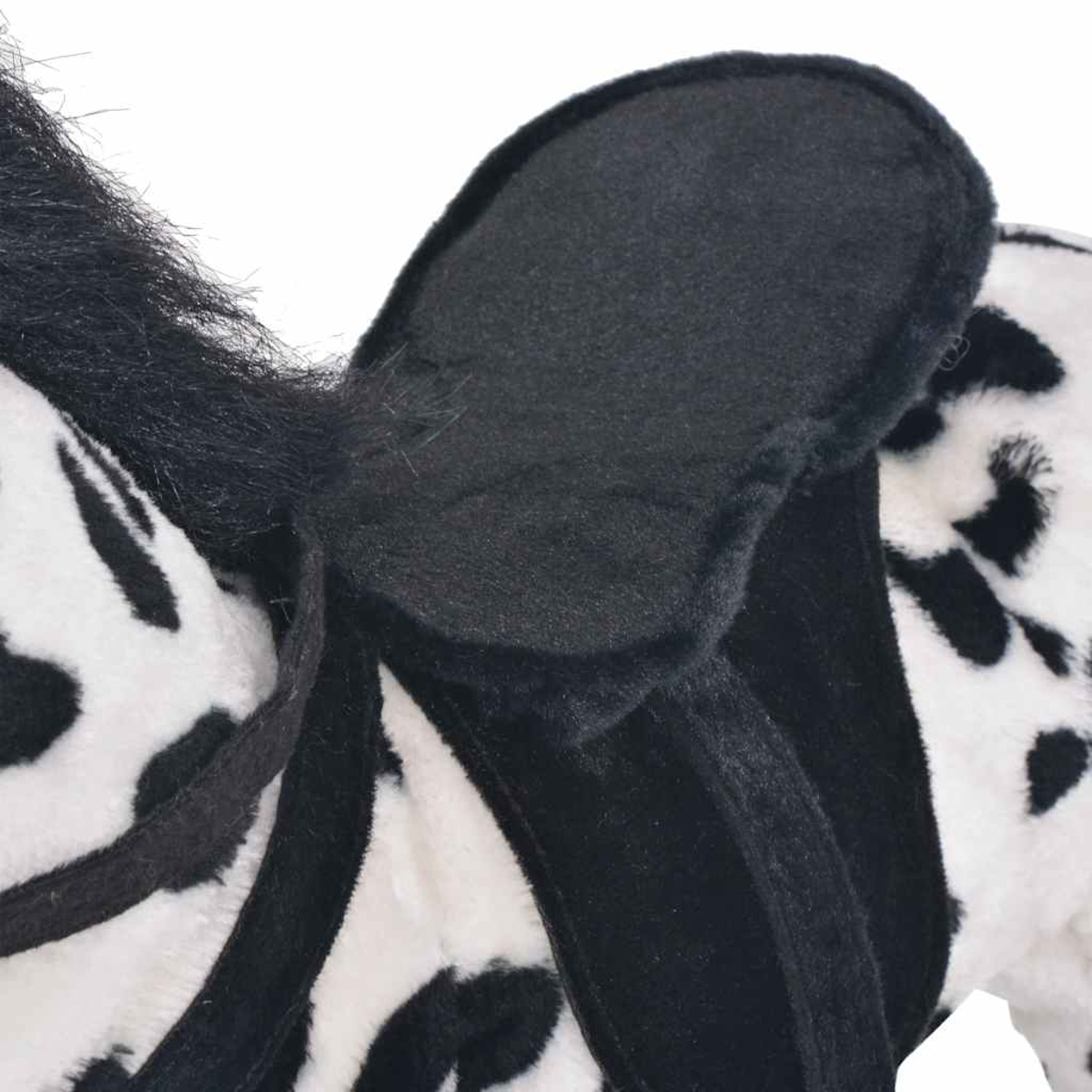 Nahaufnahme eines Plüschtierohrs mit schwarzen Flecken und schwarzem Fell.