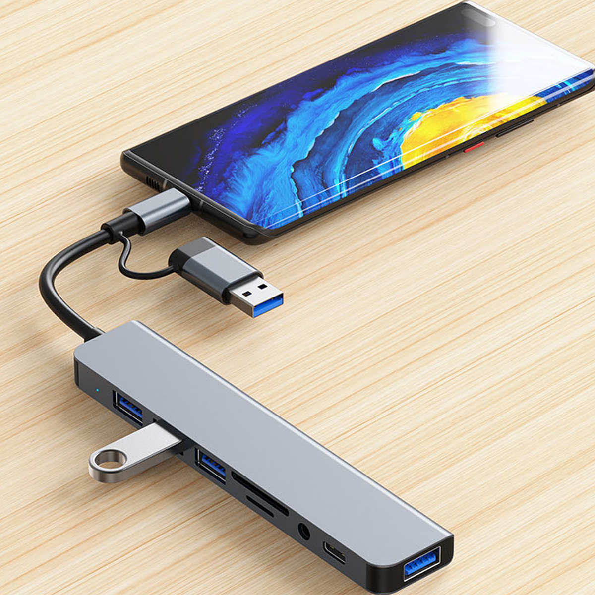 Ein USB-C-Hub ist mit einem Smartphone verbunden, das auf einem Holztisch liegt.