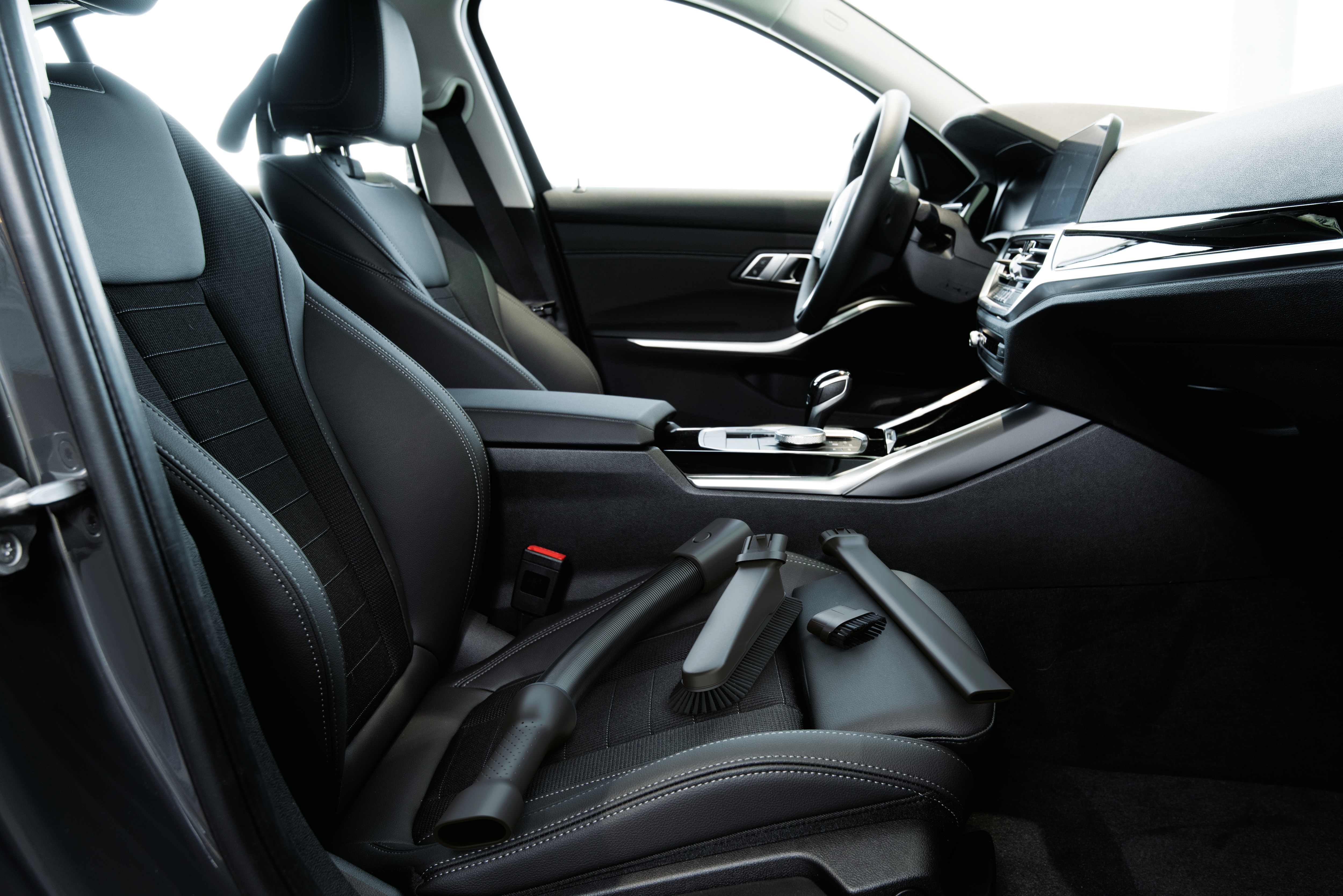 Interior de coche con asientos de cuero negro y accesorios.