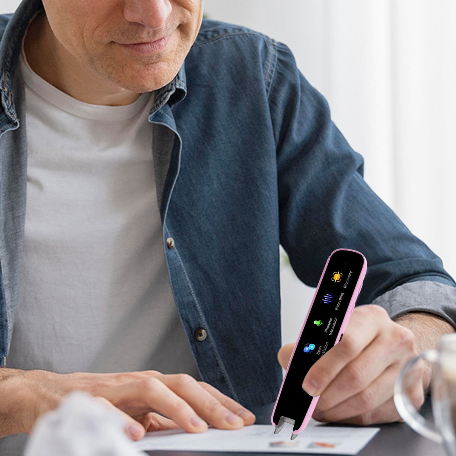 Mann in Jeanshemd scannt Text mit rosa Stift.