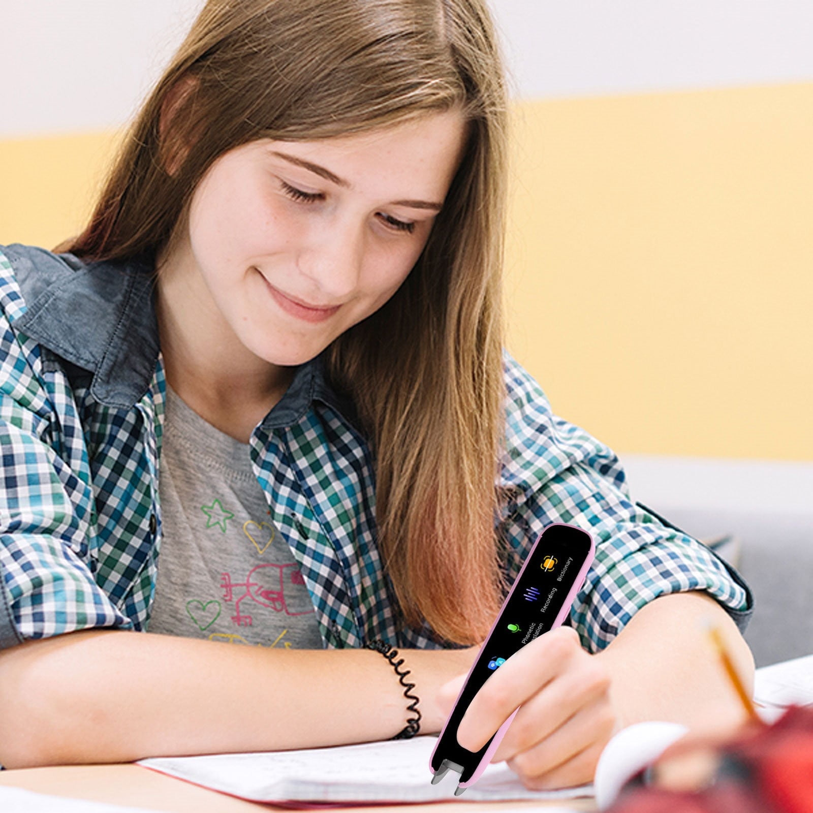Ein Mädchen schreibt in ein Notizbuch und benutzt einen pinken Stift mit Bildschirm.