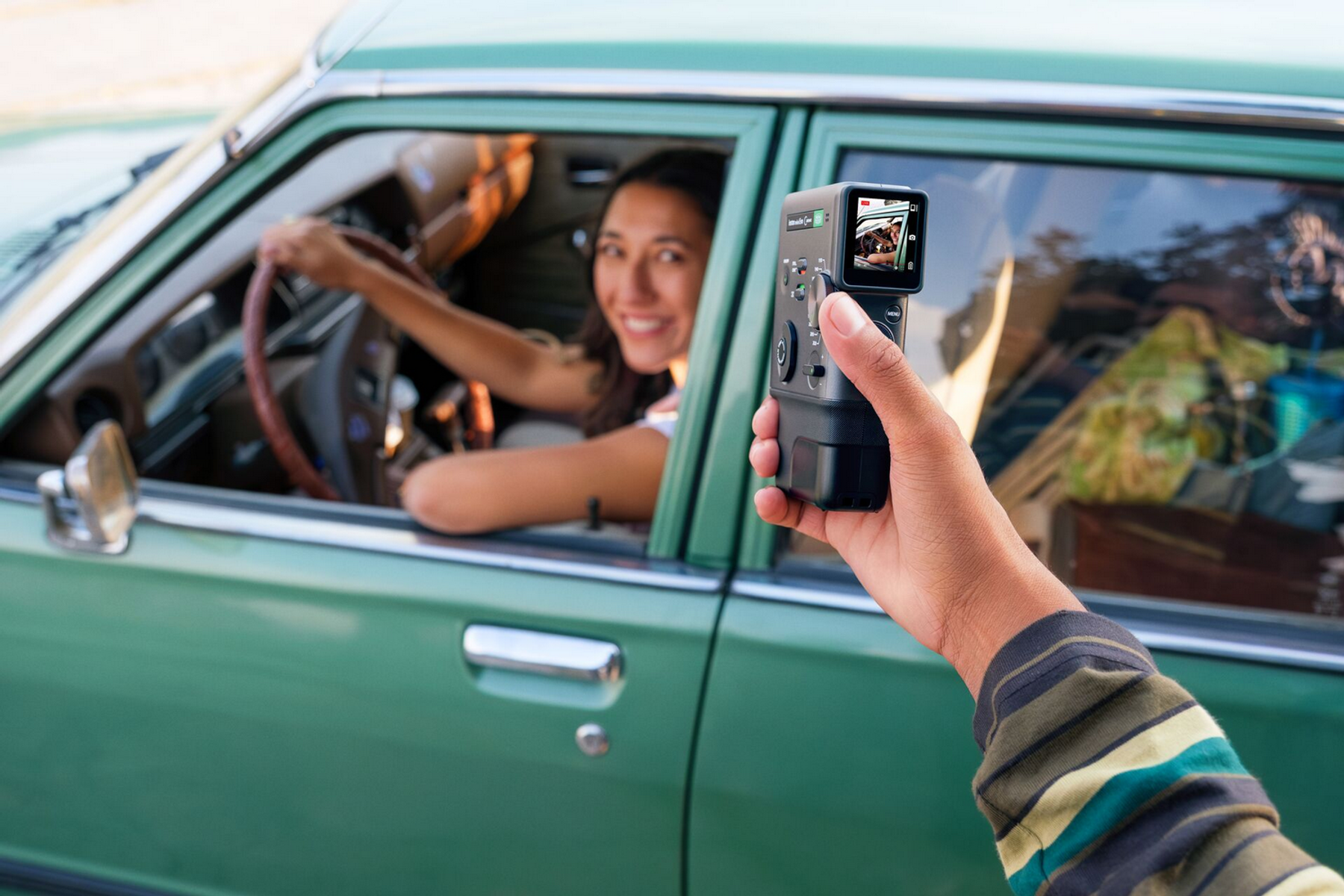 Una mujer conduce un coche mientras una cámara la filma.