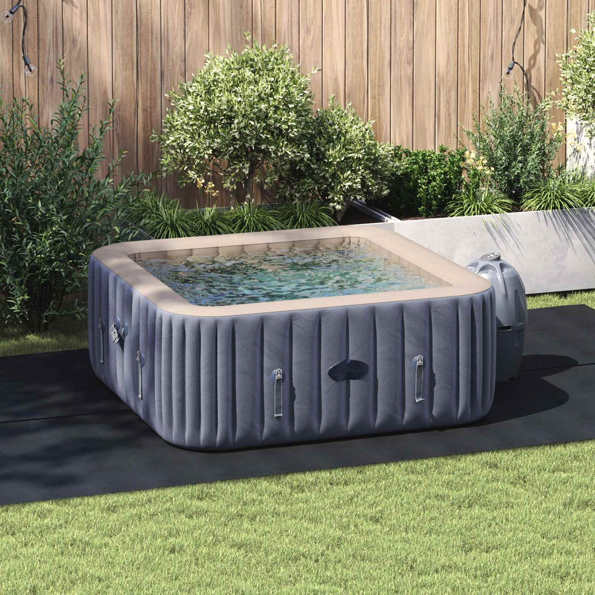 Aufblasbarer Whirlpool im Garten mit Holzverkleidung und Pflanzen.