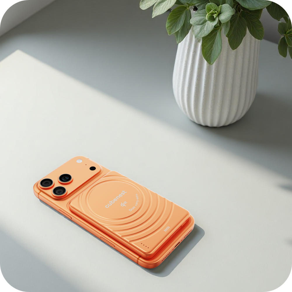 Orangefarbenes Smartphone mit Kamera und Ladehülle auf einem Tisch.